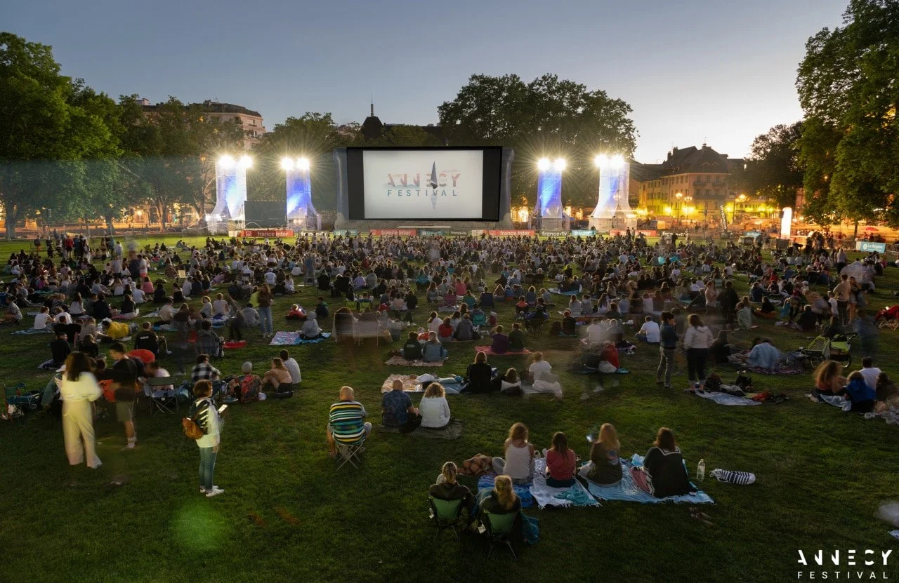 Vue panoramique de la projection en plein air du Annecy Festival au crépuscule