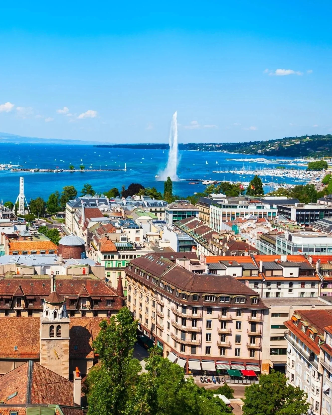 Vue aérienne de Genève avec le Jet d'Eau sur le lac Léman, toits de la vieille ville et port de plaisance en arrière-plan