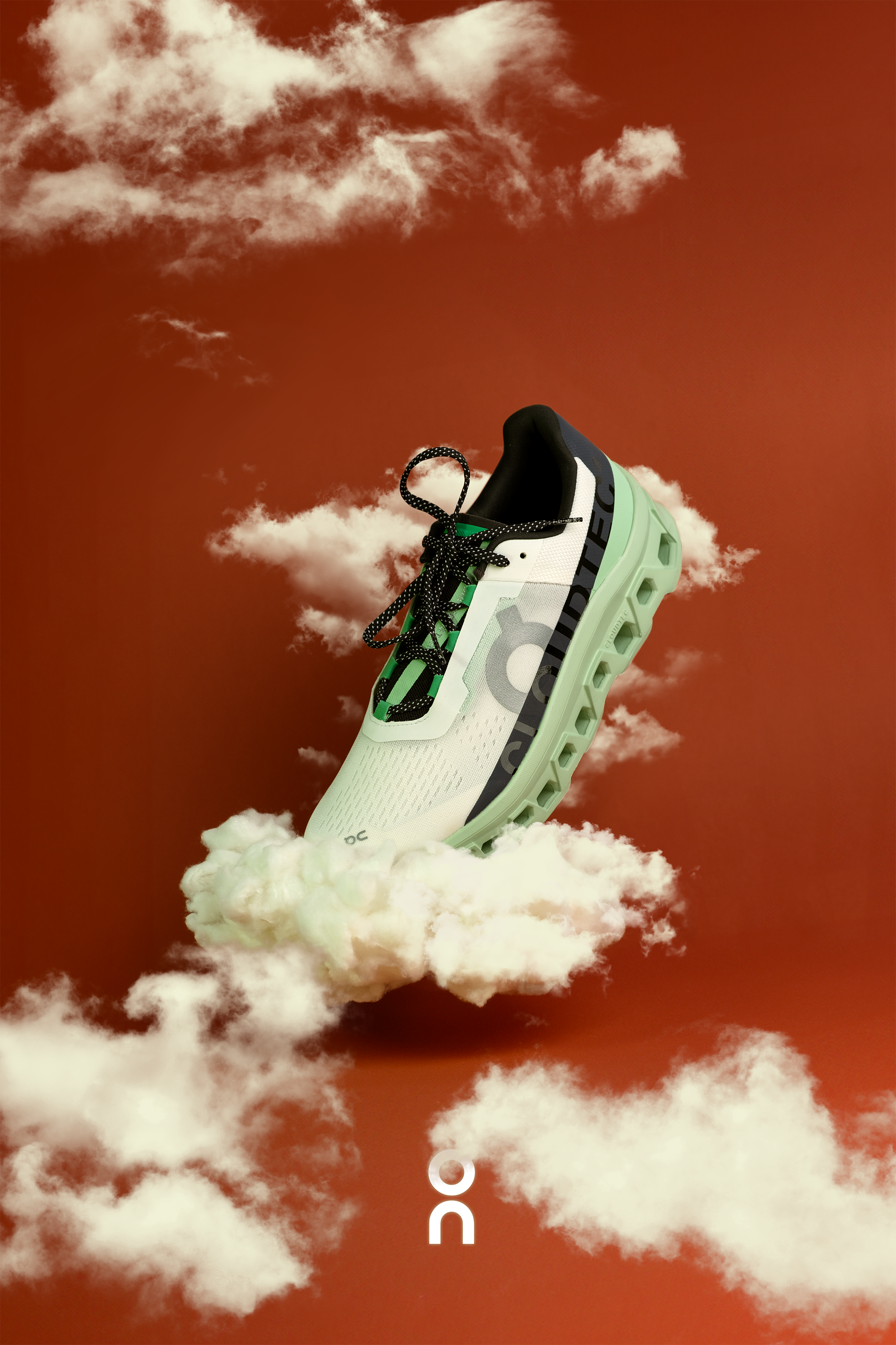 A running shoe floating among clouds against a reddish background. Packshot try for On Running