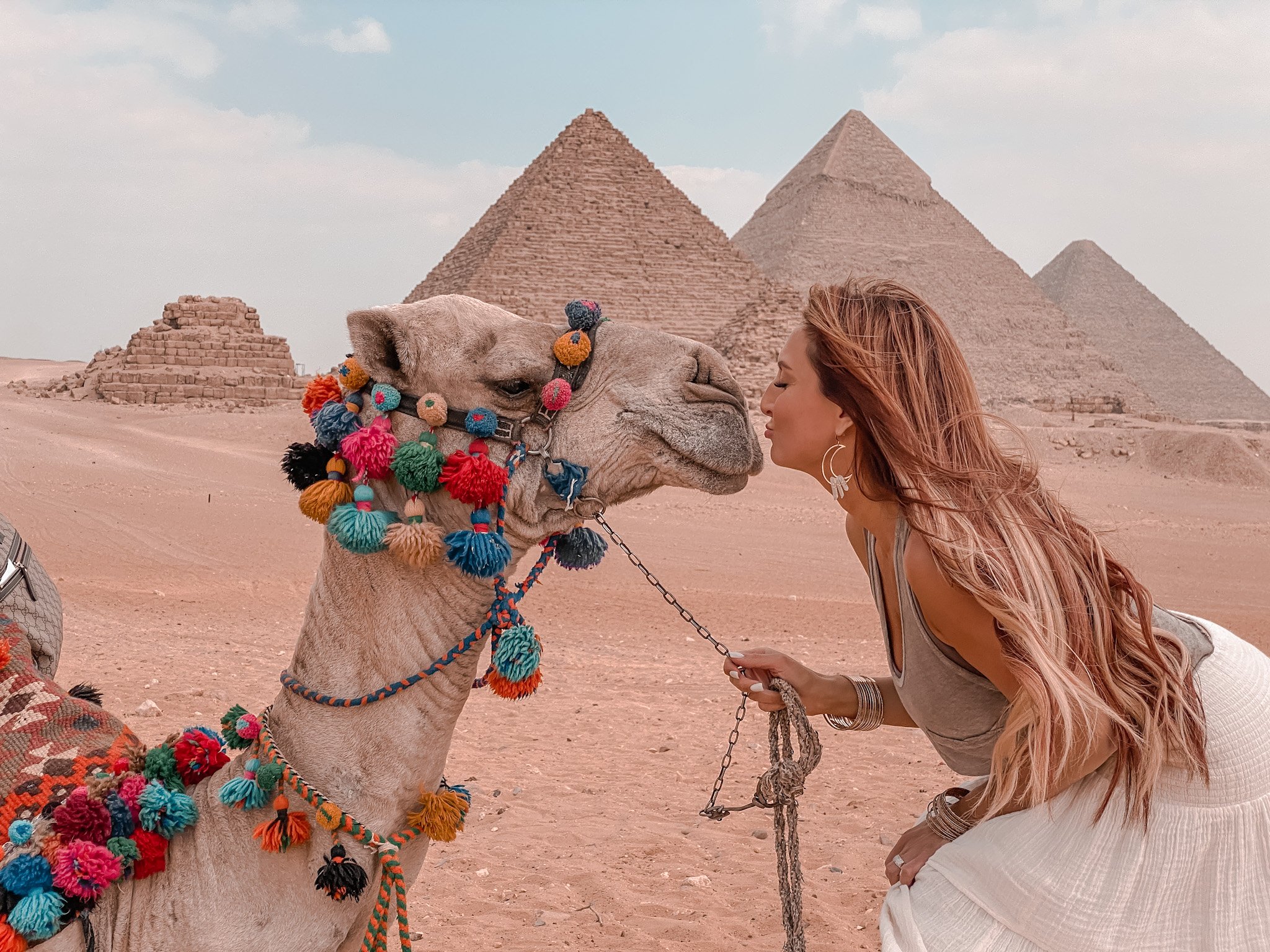 Solo female traveler with camel at the great pyramids of Egypt