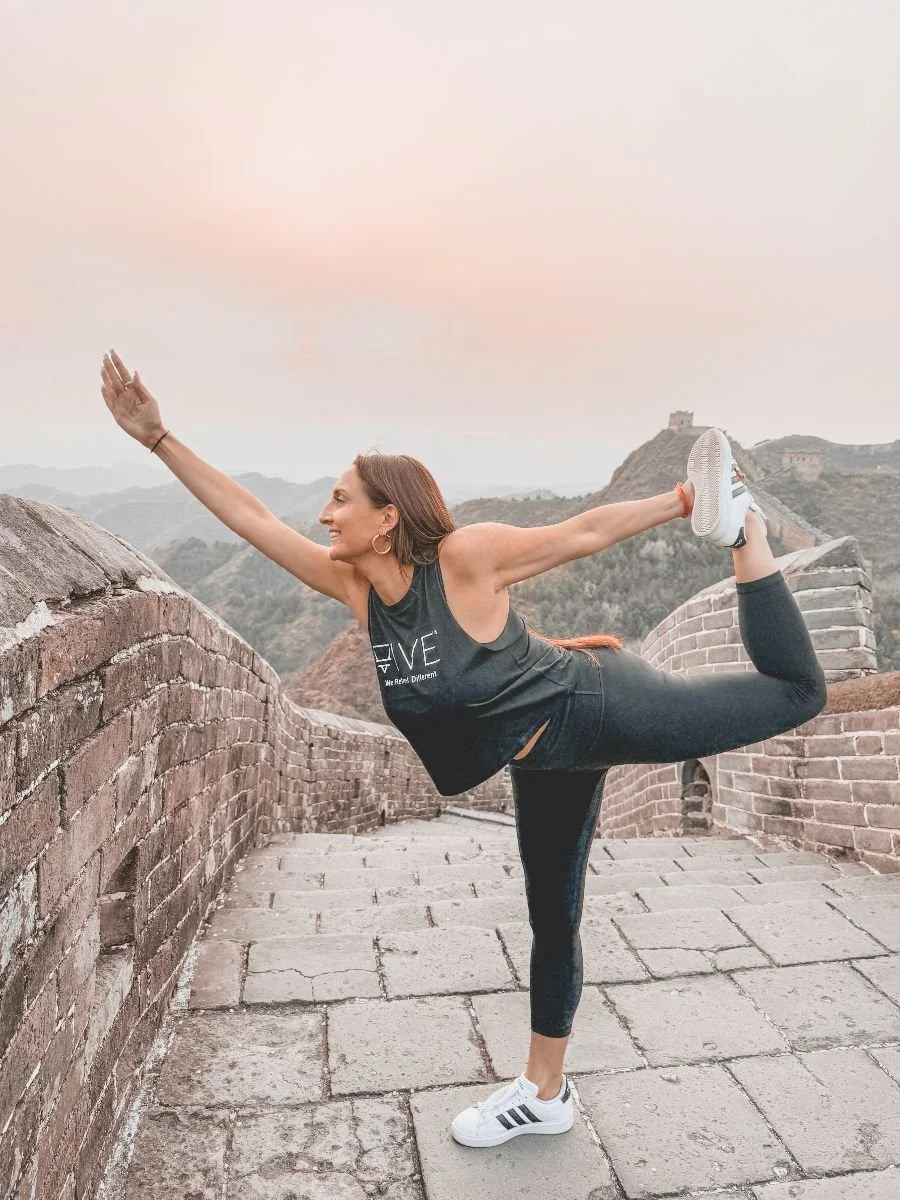 Michelle Ruiz, founder of VIVE Society Travel, doing yoga at the Great Wall of China in Beijing.