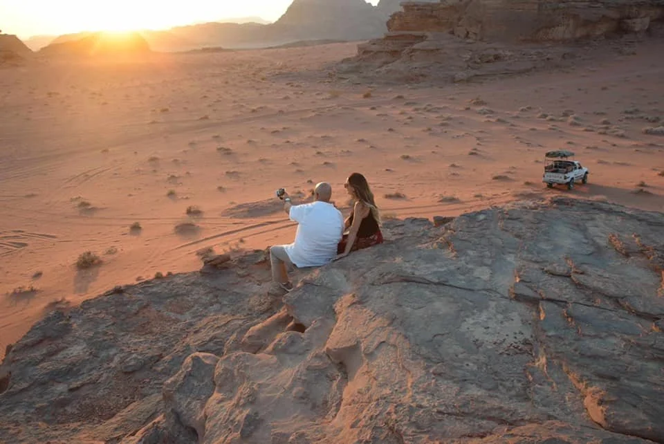 Couple watching the sunset in Wadi Rum Desert