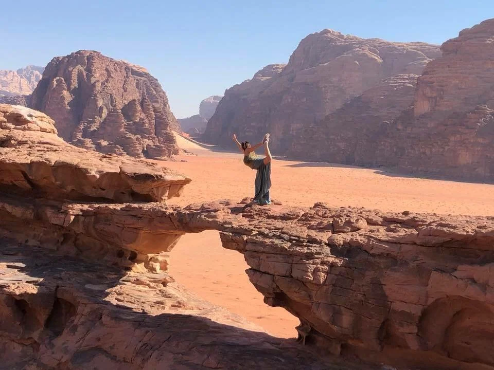Michelle Ruiz doing yoga pose on rock formation in Wadi Rum Desert, Jordan
