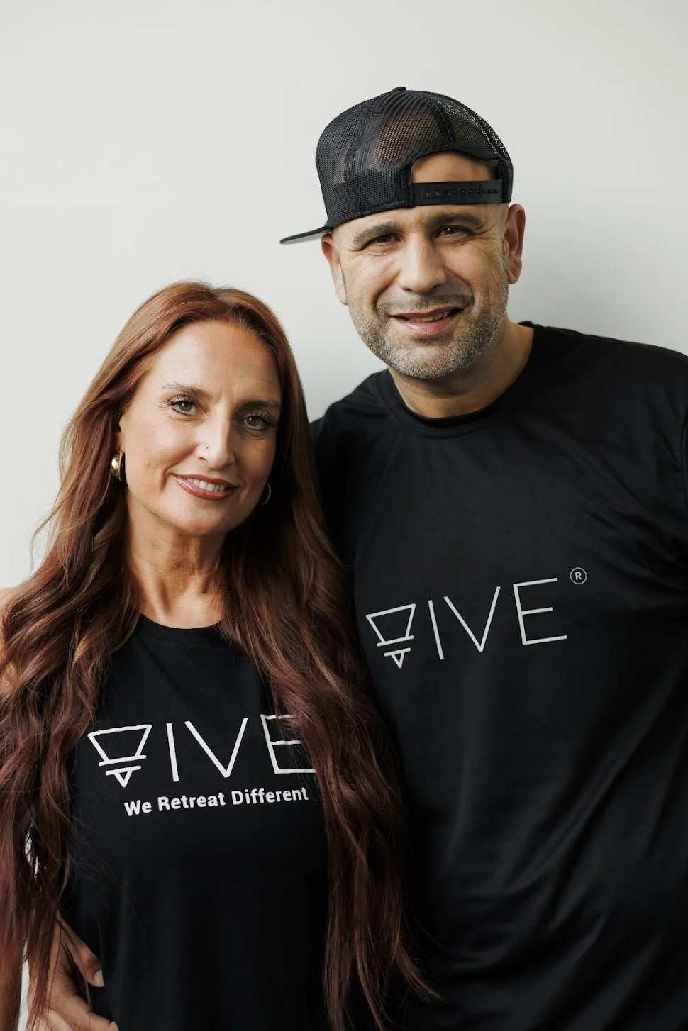 The founders of VIVE Society Travel bio picture. Michelle and Nelson Ruiz wearing the famous  balck and white VIVE travel logo shirts.
