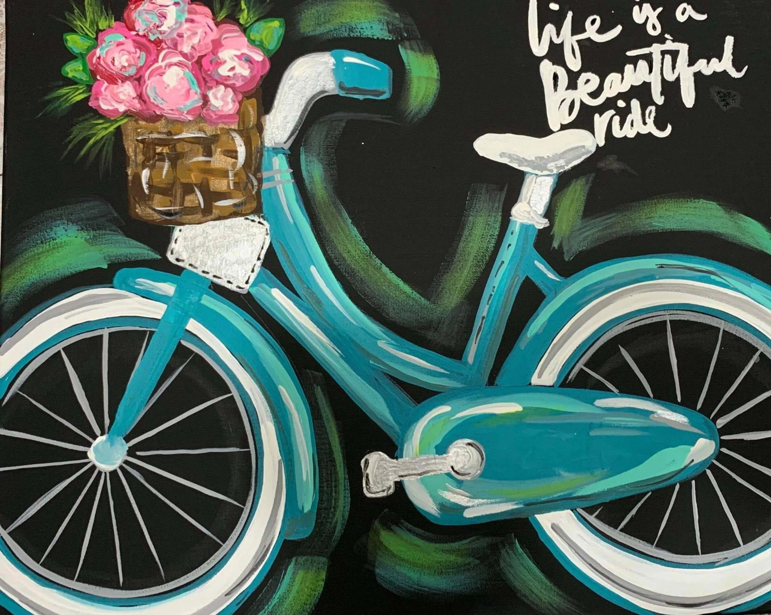 Painting of a vintage blue bicycle with a basket of pink flowers on the front. The bicycle has white and black tires and a white seat. There is a handwritten quote at the top right that reads, 'life is a beautiful ride'.