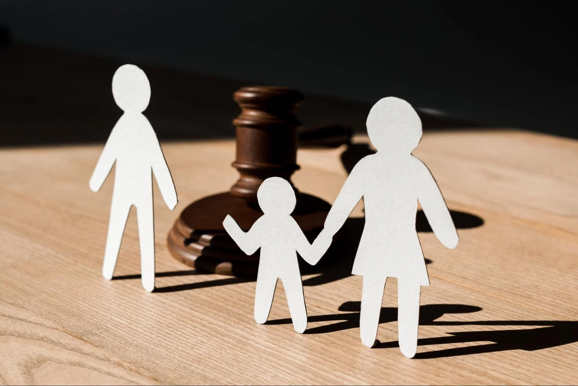 Family paper cutouts and gavel representing child custody mediation and parenting agreements