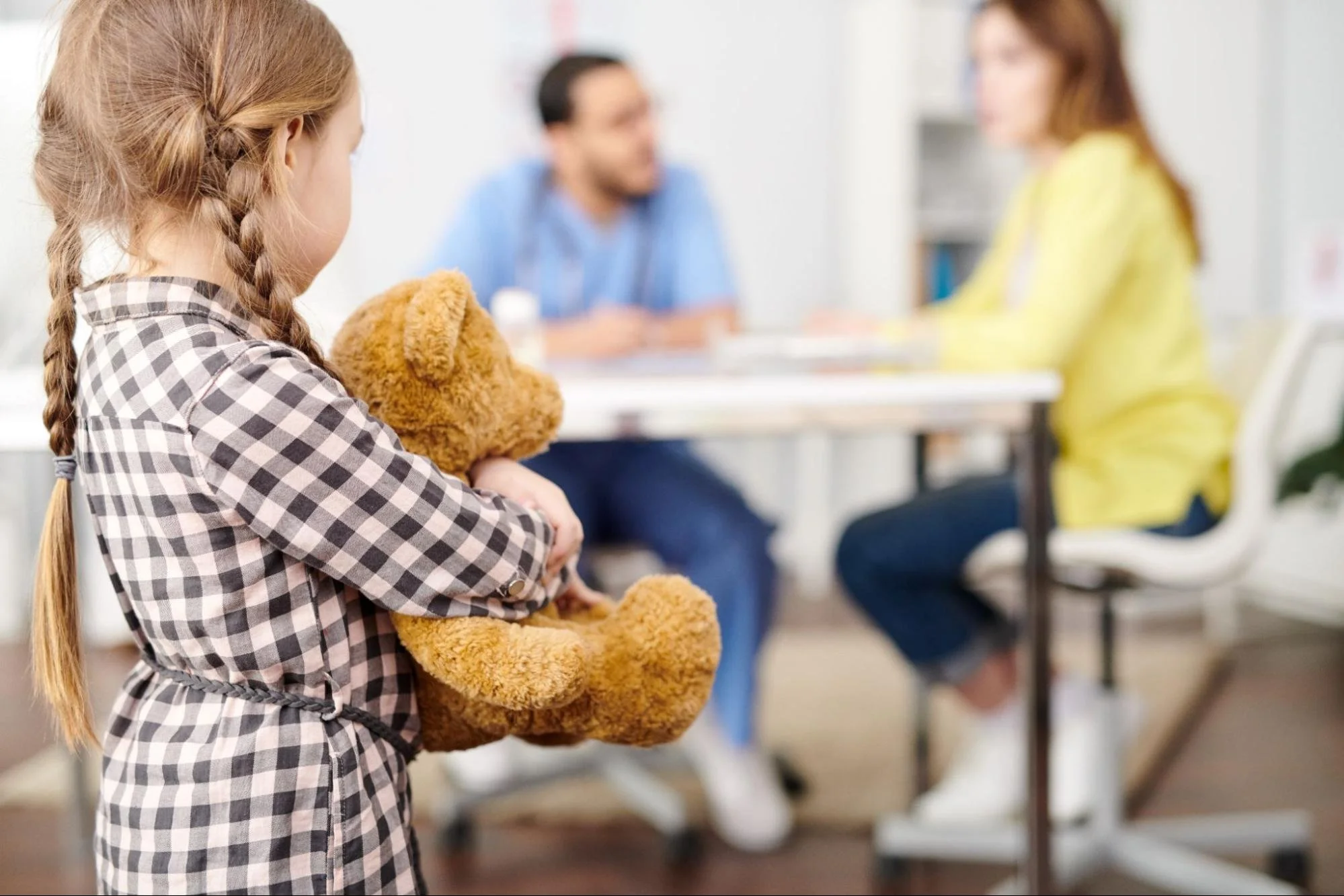 Nervous young girl watching her parents during a child custody mediation session