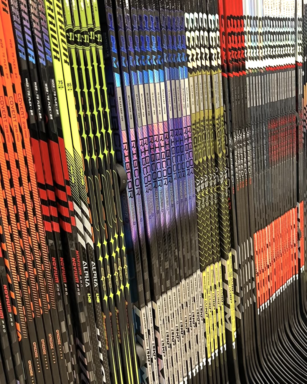 Hockey sticks of different colors lined up