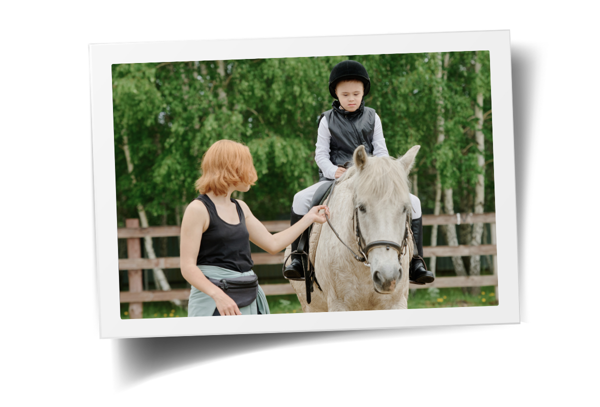 A child participating in adaptive riding with a calm horse and side-walker support at HorseSpeak at Cowgirl Up Ranch.