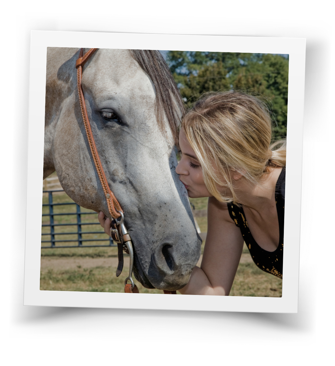 A woman gently leaning in with a horse, sharing a quiet moment of connection and trust in an outdoor ranch setting.
