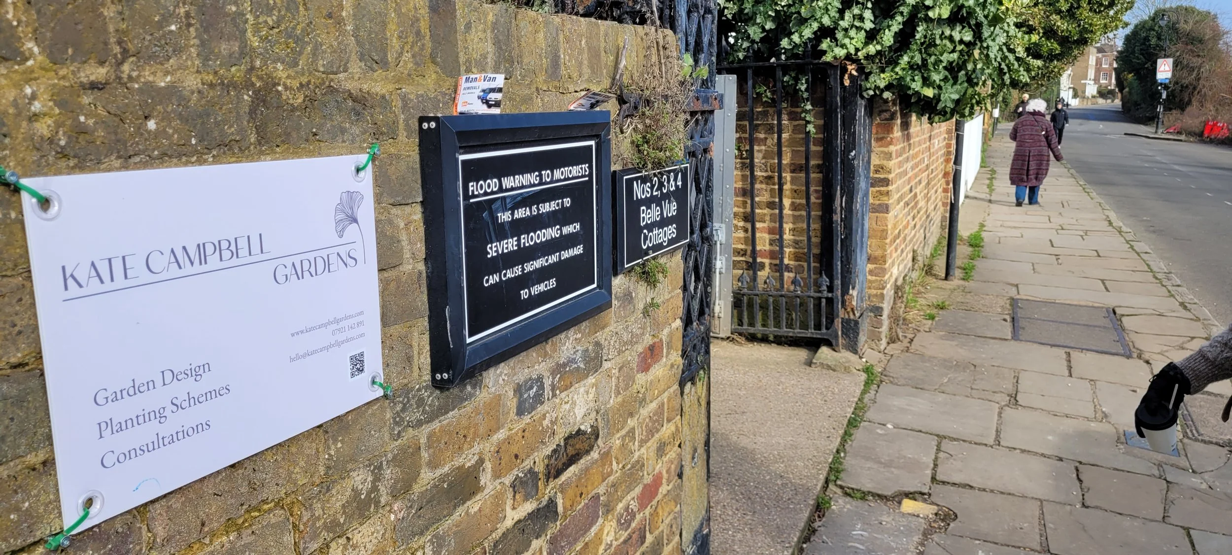 black sign on a brick wall warning motorists of severe flooding and damage to vehicles