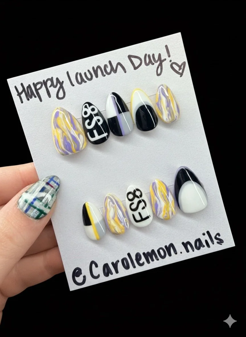 Decorative fingernails with colorful patterns and text, displayed on a card that reads 'Happy Launch Day!,' with the Instagram handle '@carolemom.nails'.