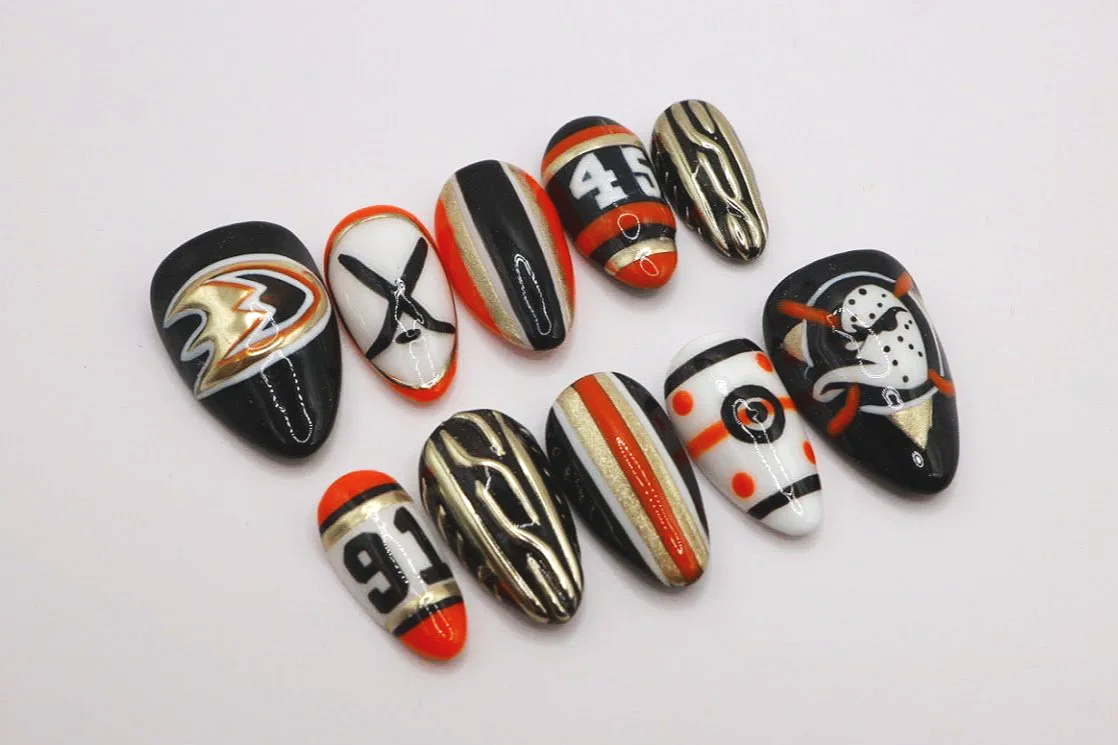 Collection of decorated football-themed nails with team logos and colors.