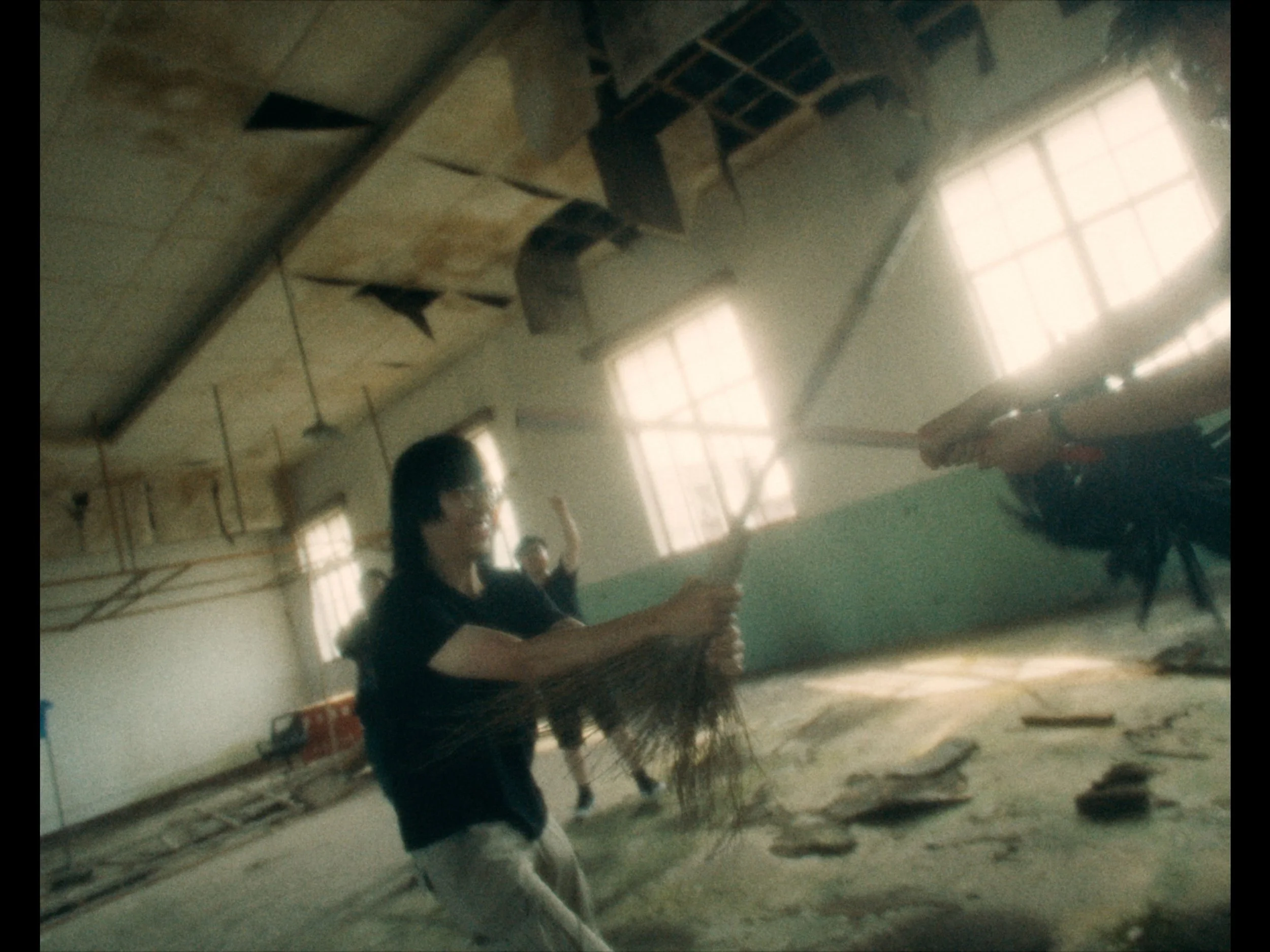 People in a gym practicing martial arts or self-defense with sticks during a training session.