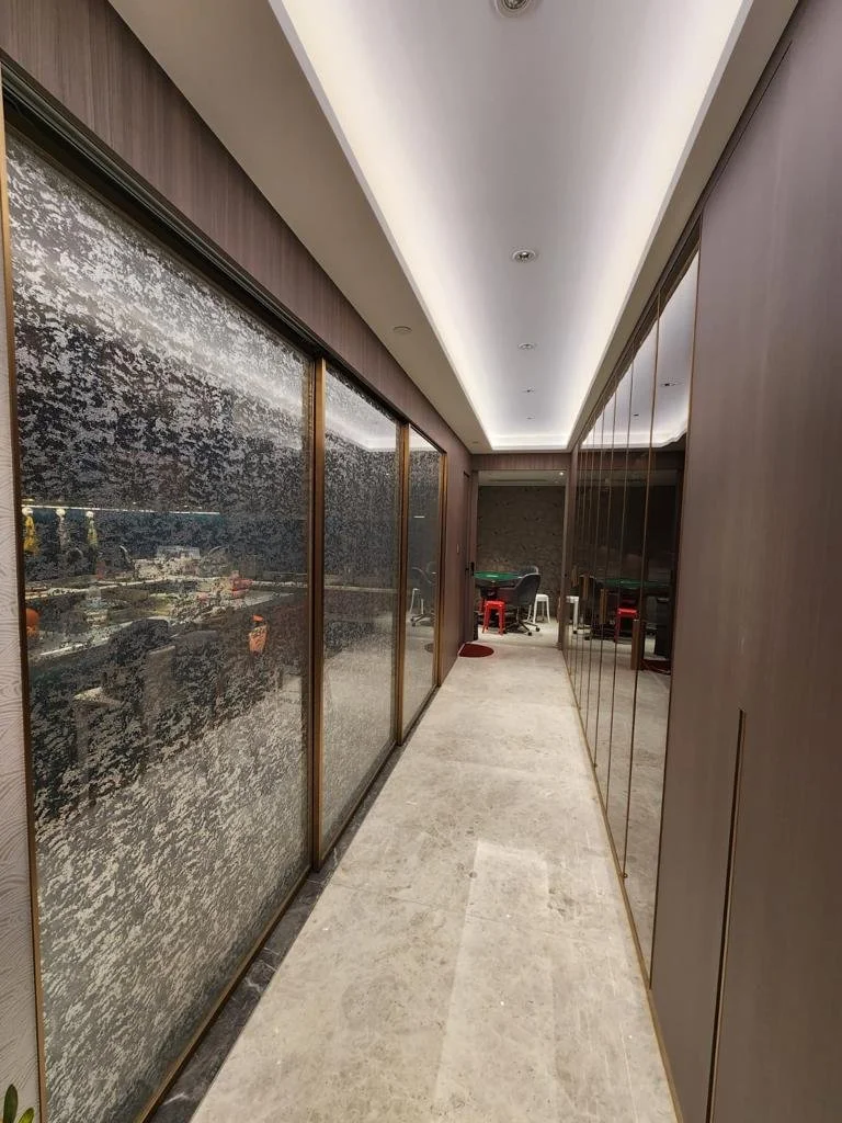 Elegant corridor design at Chang Kung Koon 張公館, with textured stone feature wall, warm wood panels and concealed lighting by Egoart Design Workshop.
