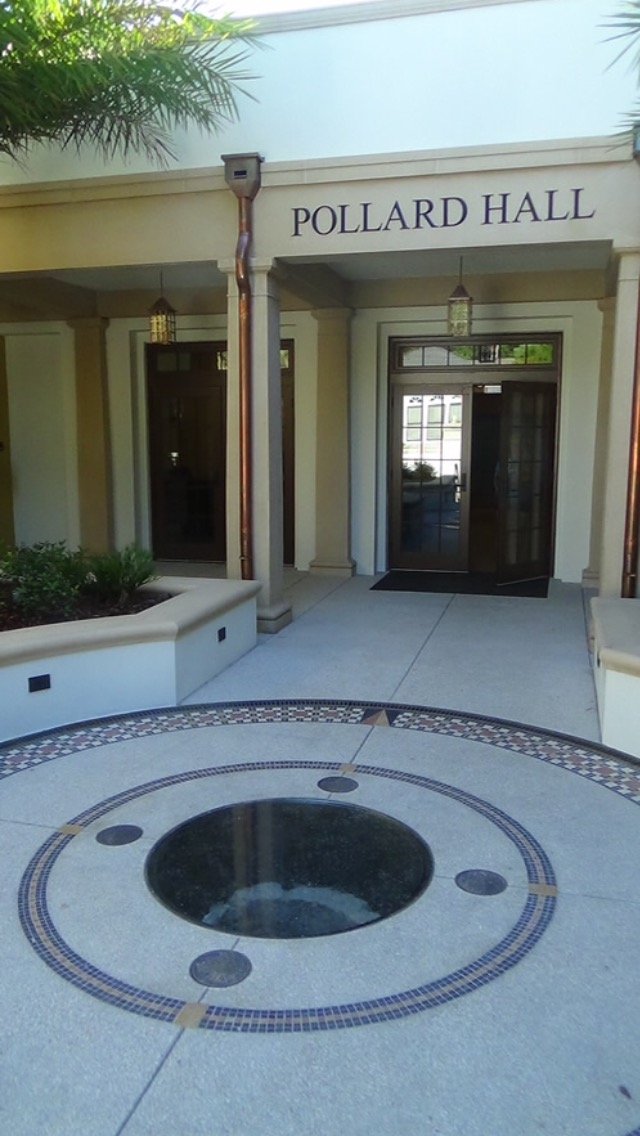 Entrance to Pollard Hall with a circular fountain design on the concrete ground in front.