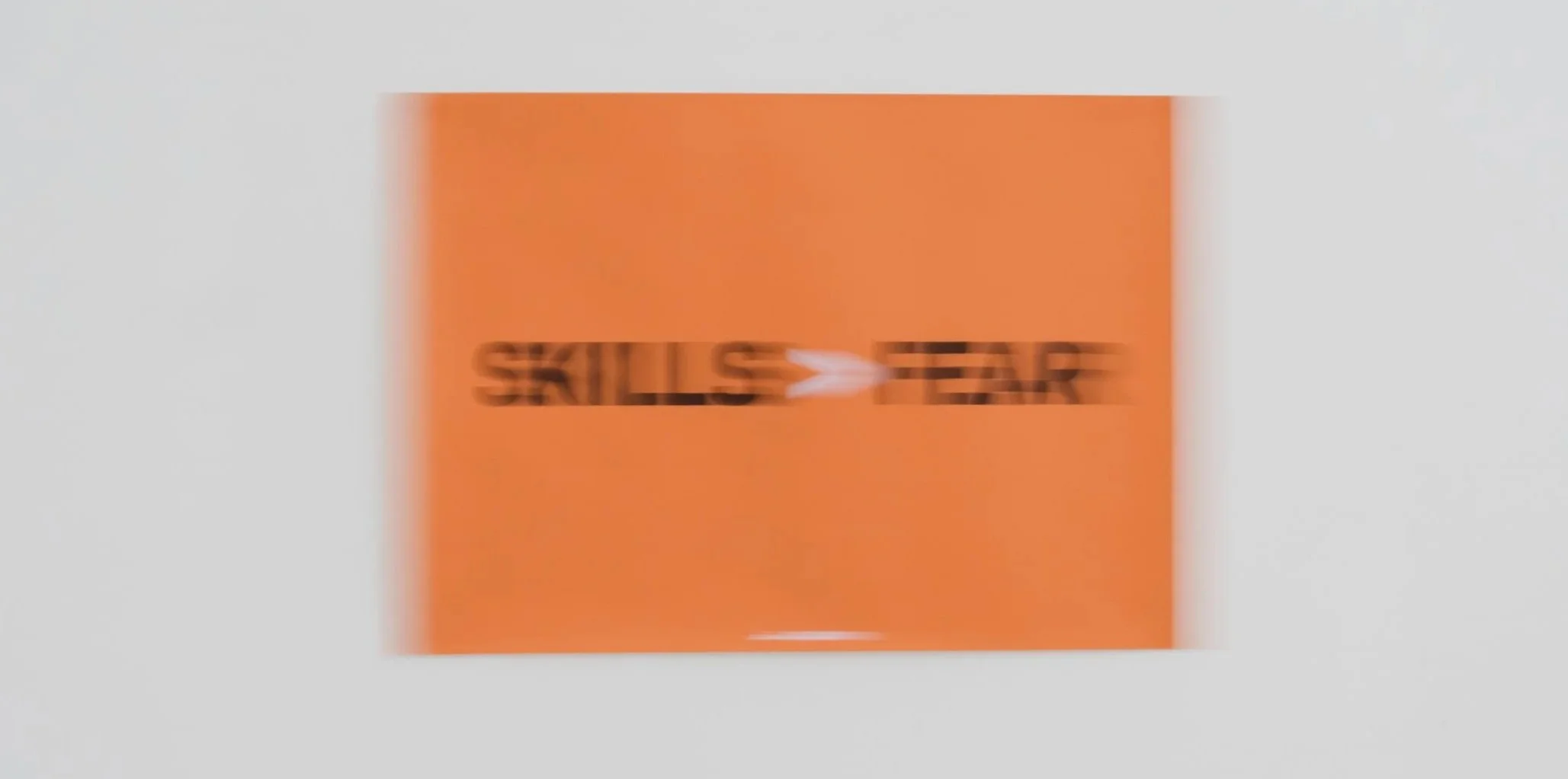 Ein orangefarbenes Schild mit den schwarzen Worten Skills > Fear.