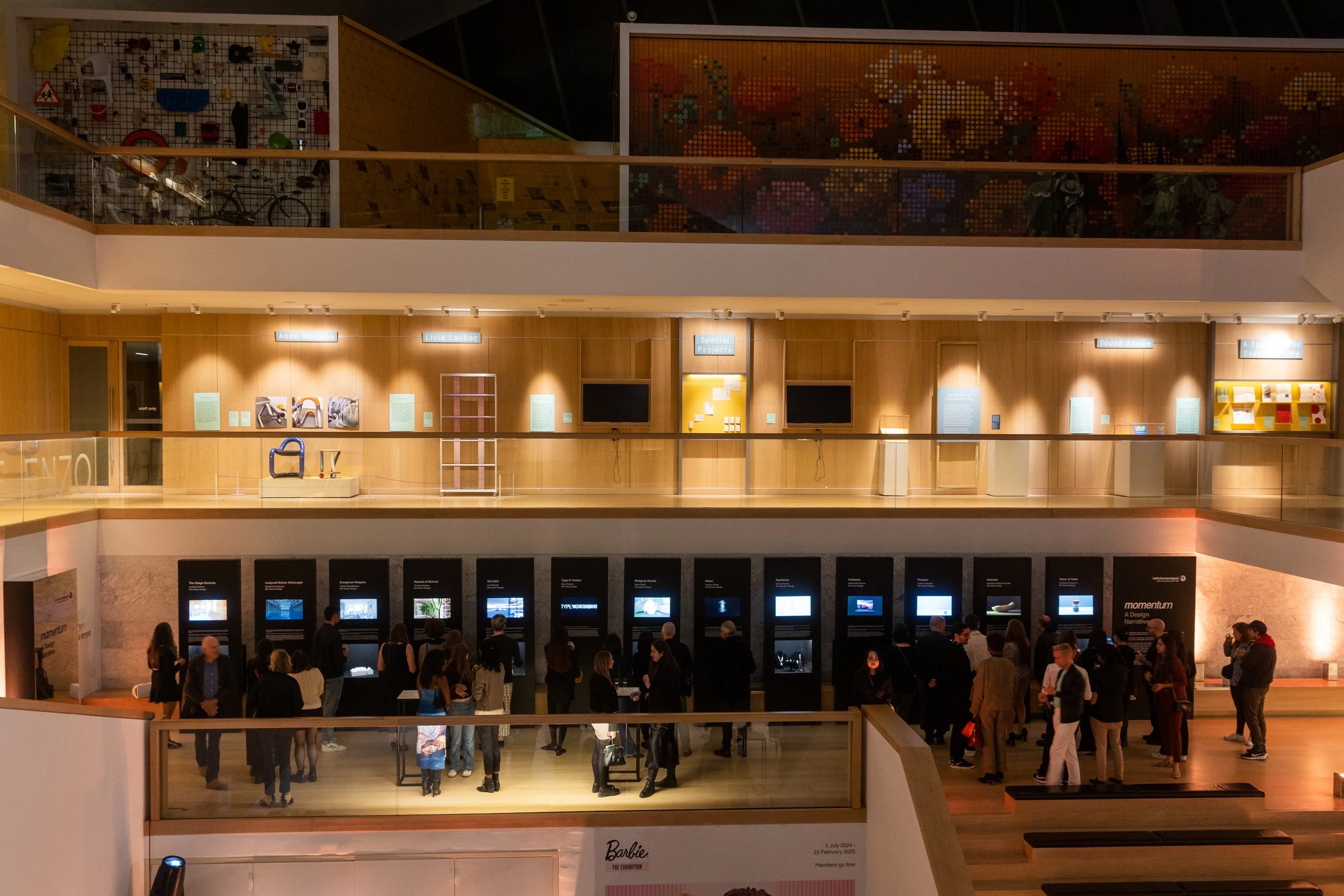 People visiting an art exhibit with digital screens and displays in a museum.