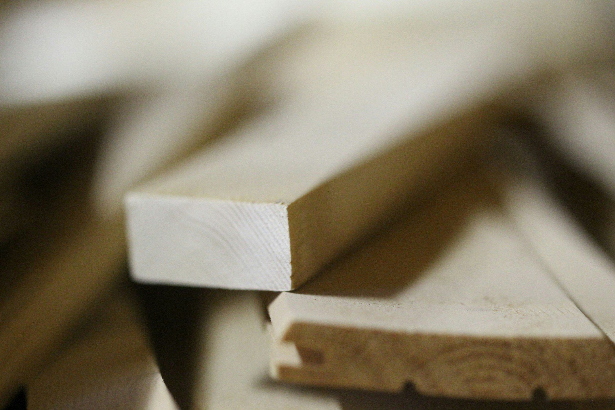 Close-up of stacked wooden pieces with smooth, light-colored surfaces and visible wood grain.