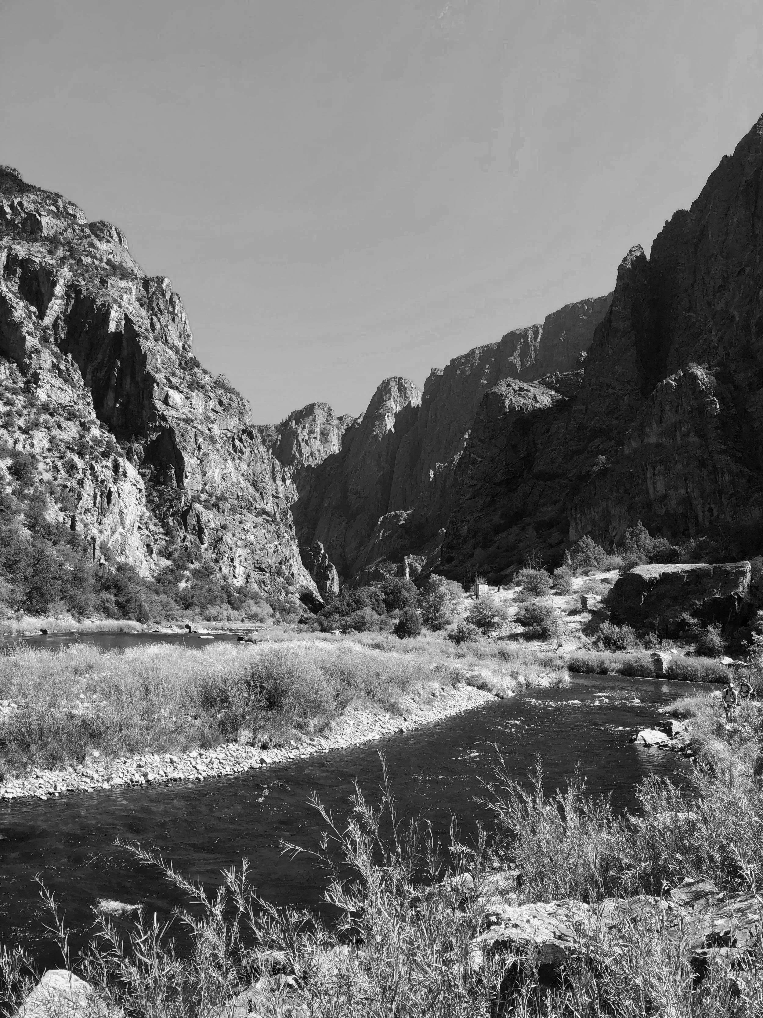 Photo of a river flowing through a canyon with tall rocky cliffs, a metaphor for life's journey