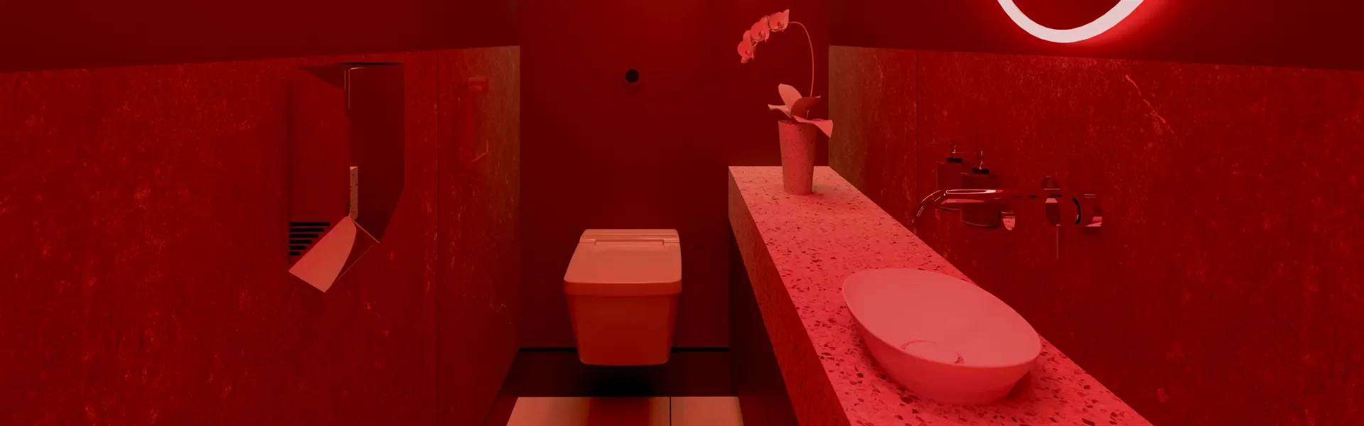 A modern bathroom with red lighting, including a white sink, a toilet, a flower vase on a speckled countertop, and a mirror.