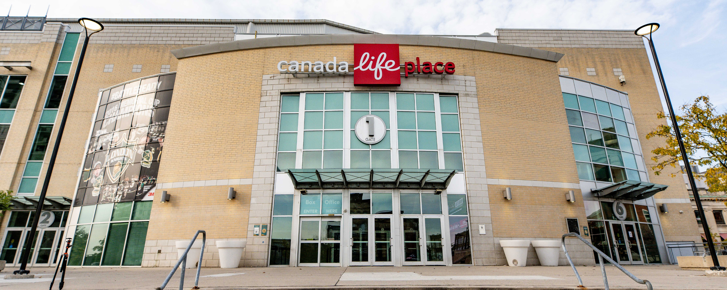 Exterior of Canada Life Place building with glass doors and windows, street lamps, and a large sign with the number 1 above the entrance.