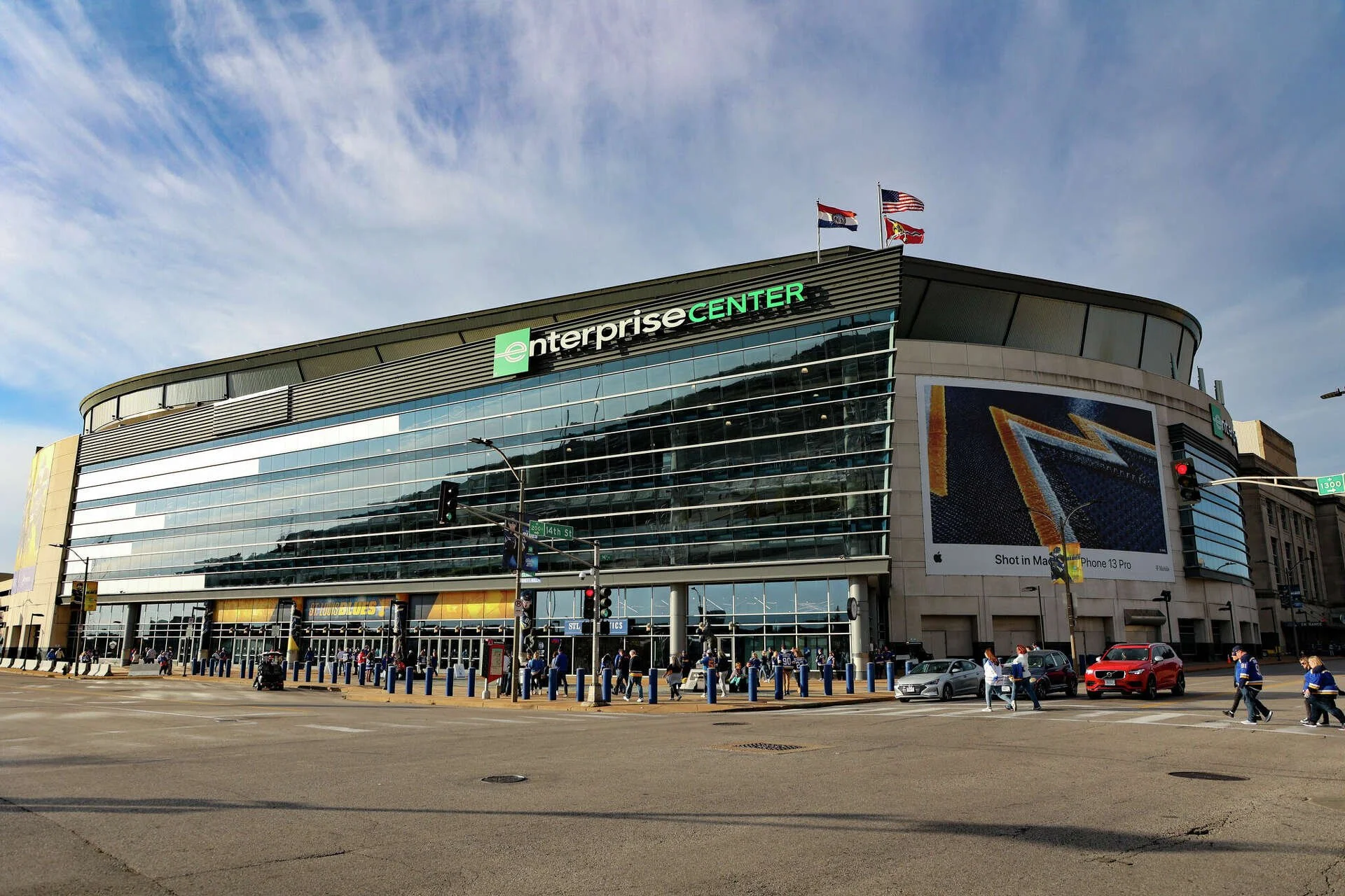 Exterior of the Enterprise Center, a large multi-story arena in St. Louis, Missouri, with crowd of people and cars in front