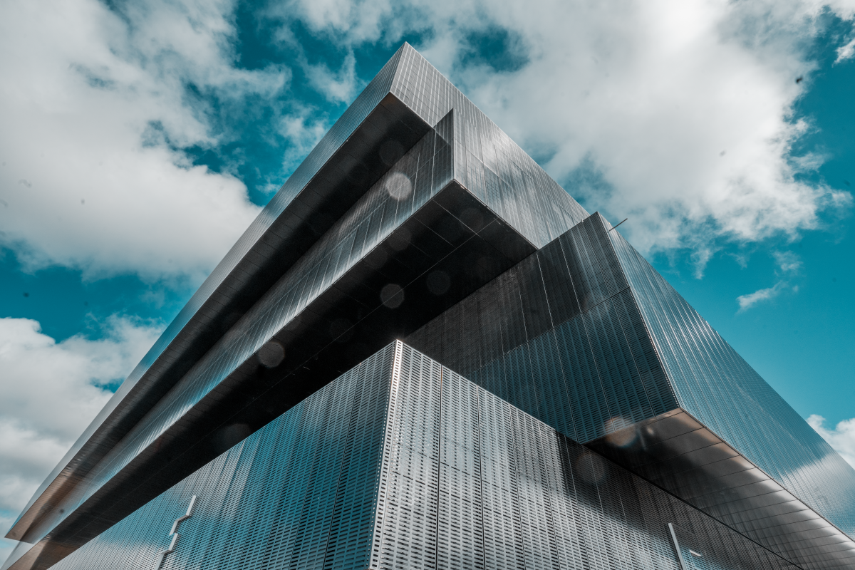 Modern high-rise building with reflective glass exterior against a partly cloudy sky.