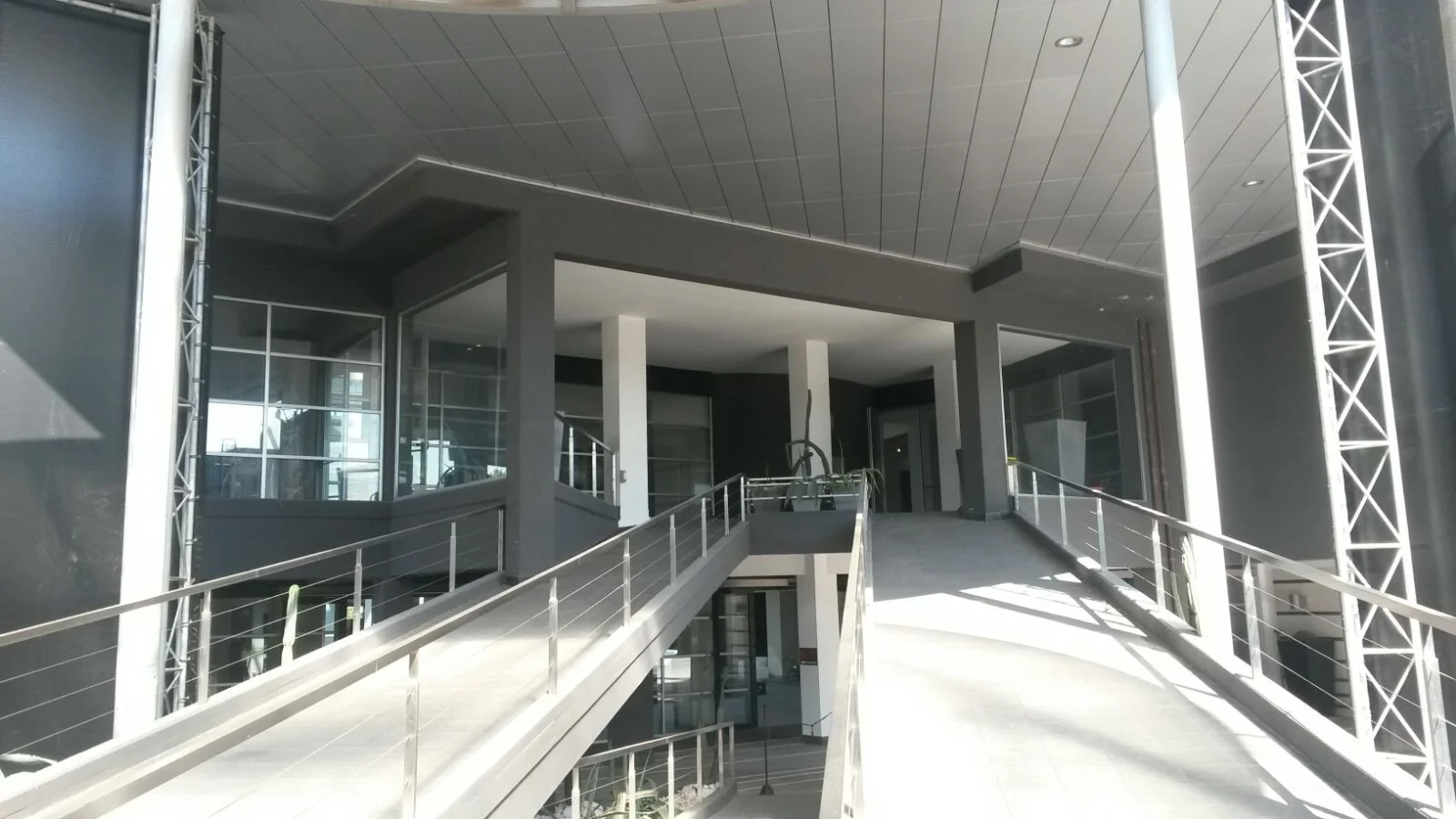 Interno di un edificio moderno in costruzione con scale e grandi finestre.