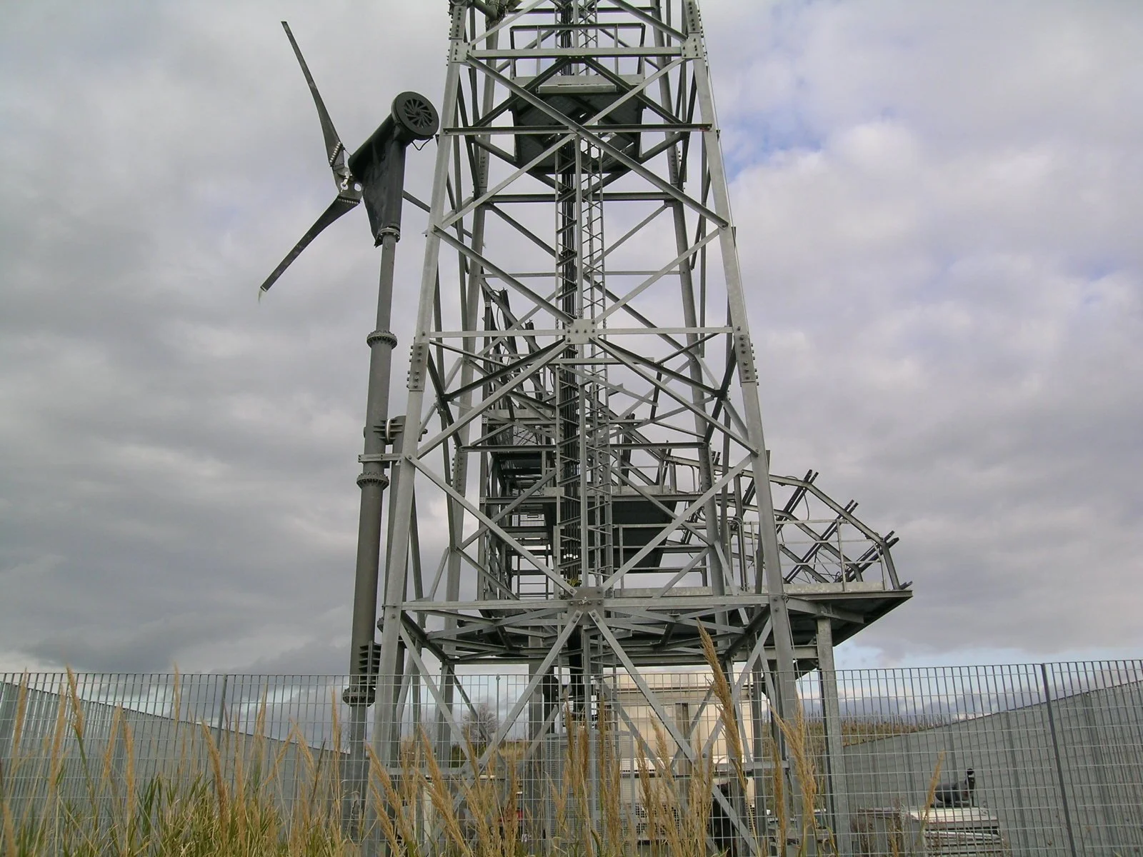 Torri di trasmissione con pannelli solari e impianto eolico in un'area aperta