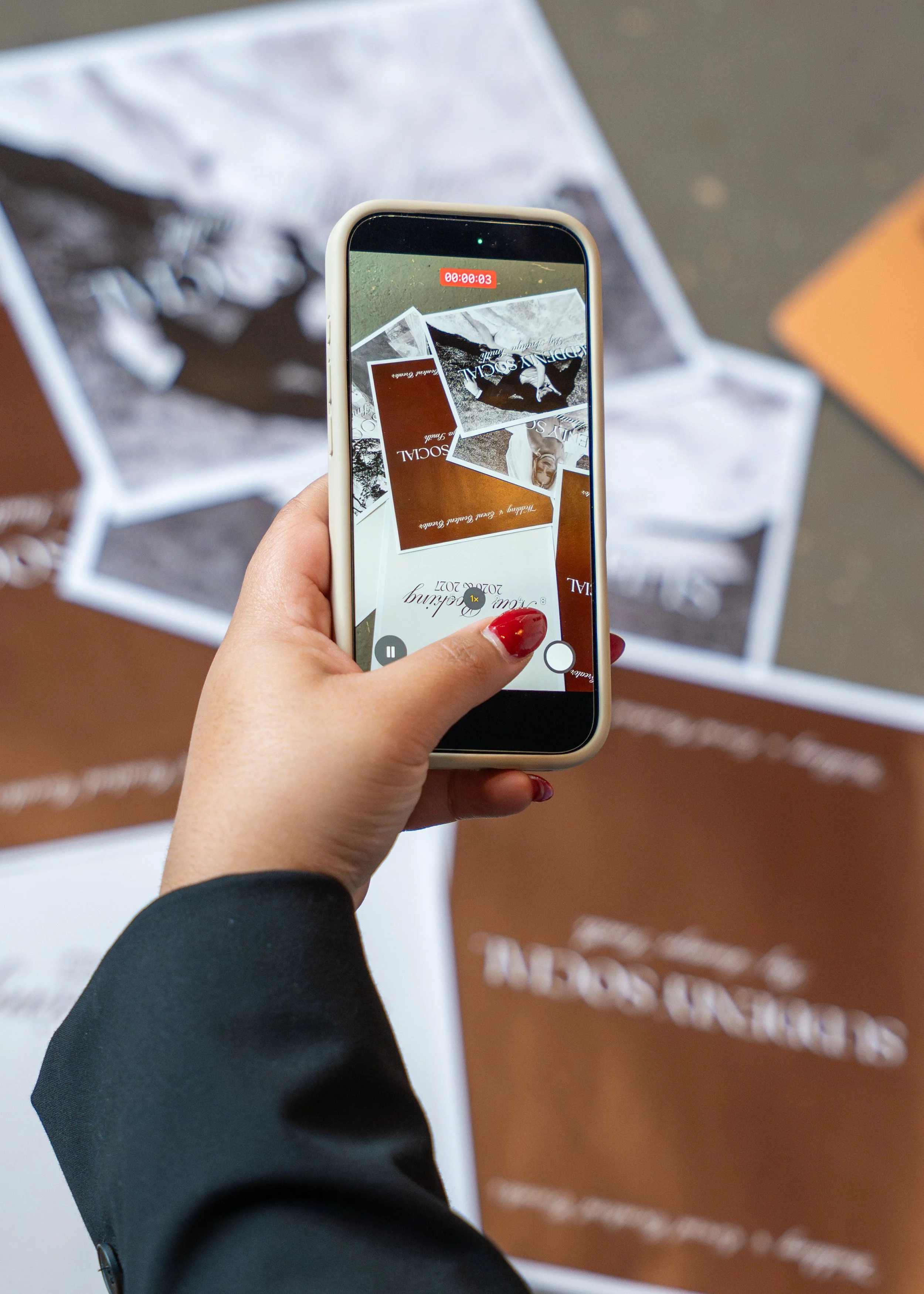 A person taking a photo of promotional posters with a smartphone. The posters advertise a seasonal sale at a store, with the store's name partially visible.