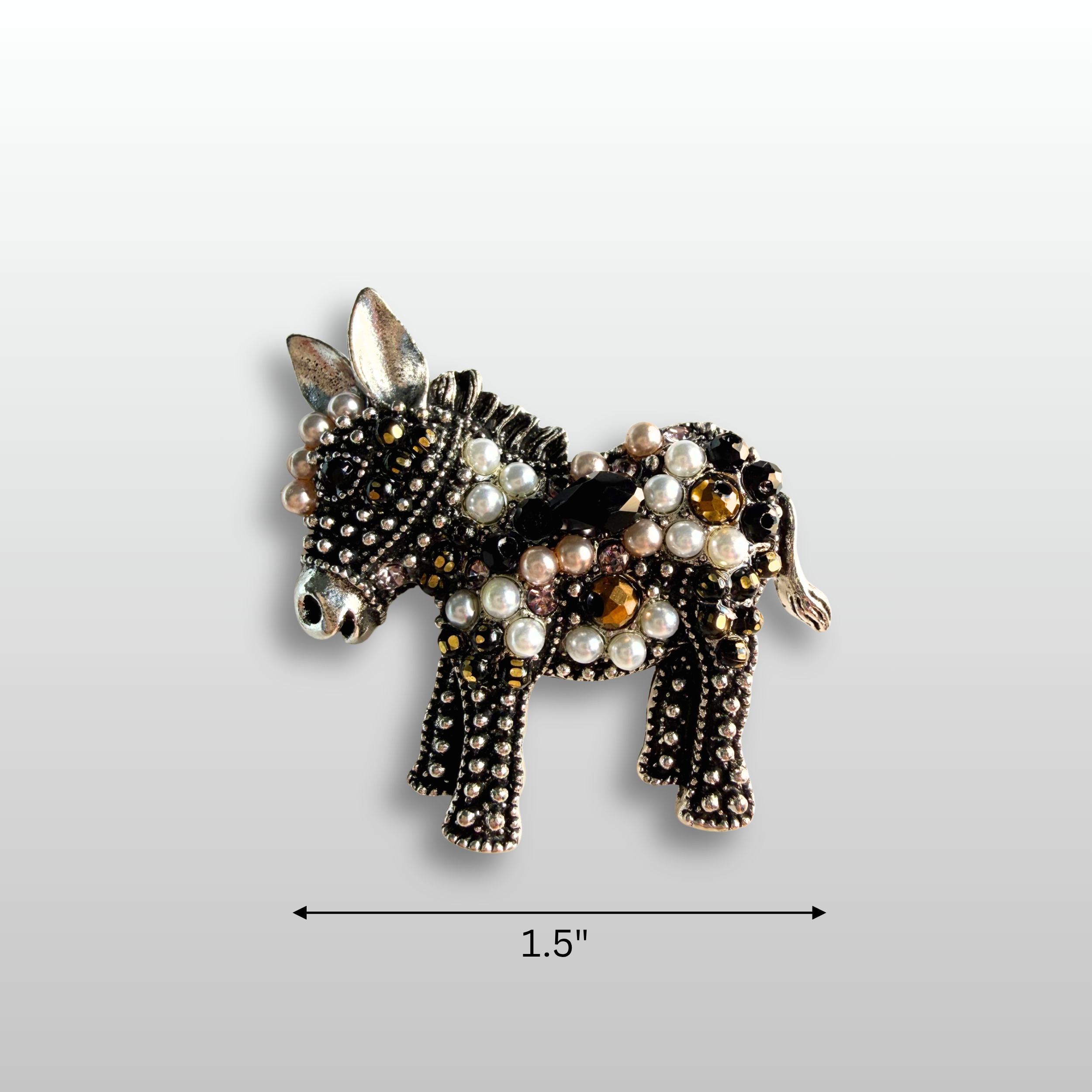 close-up of donkey brooch.  The brooch is antiqued silver with faux pearl accents and black and amber gemstones throughout.
