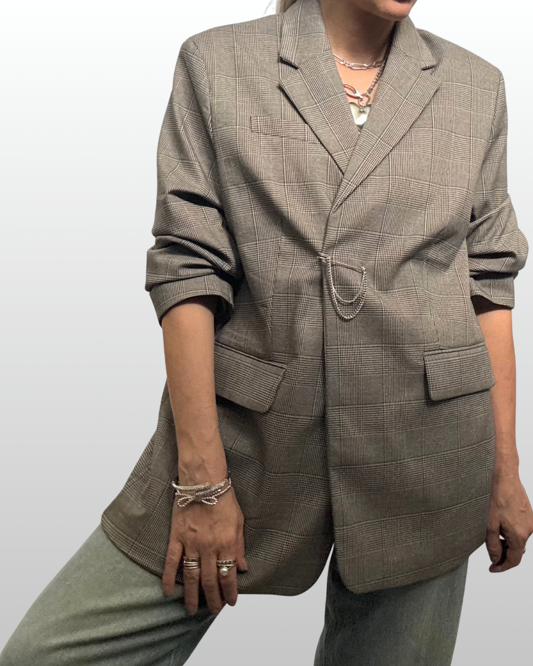 A relaxed, casual look featuring a blazer cinched naturally with a fluid draped silver pin closure instead of a button.