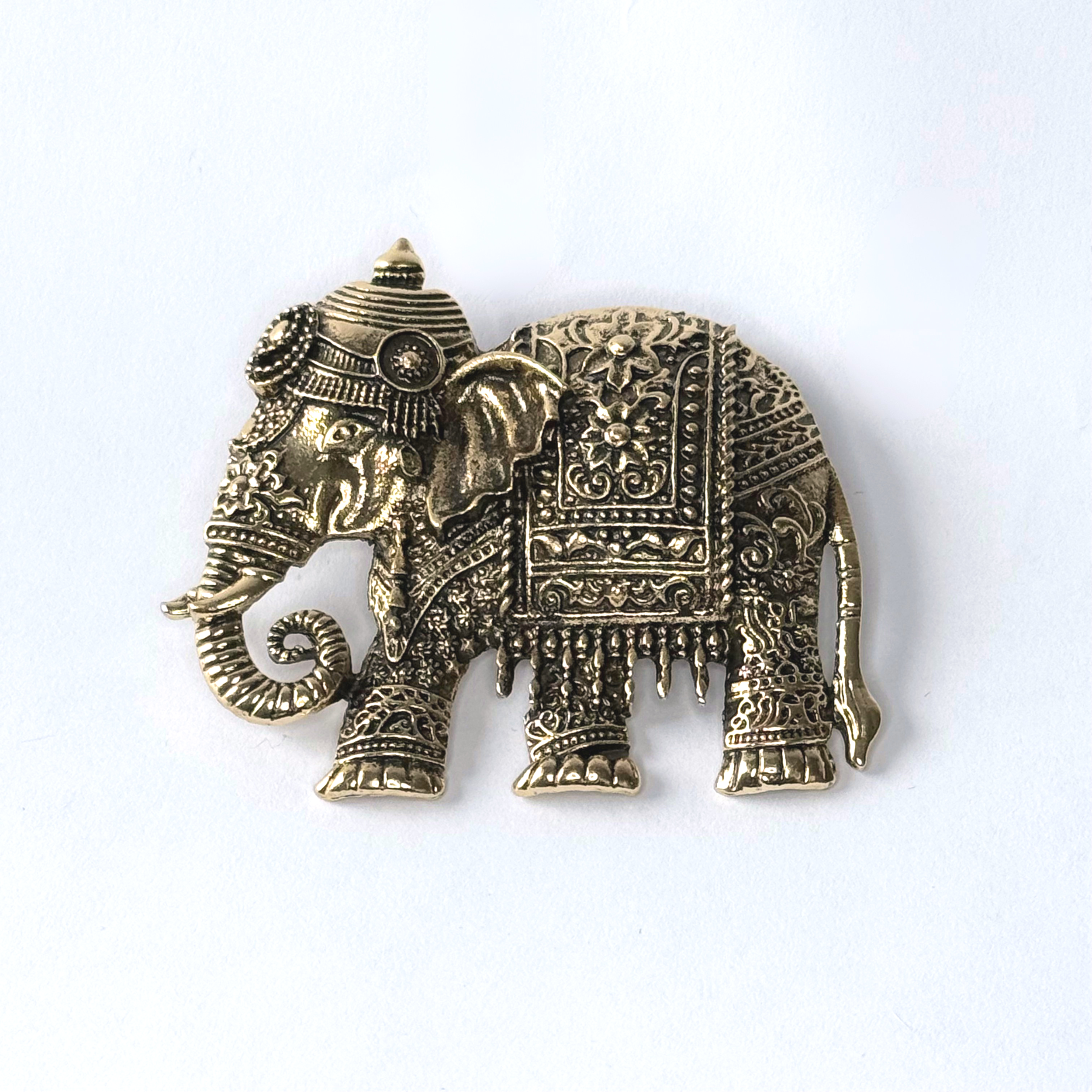 Close up of matte gold toned elephant brooch.