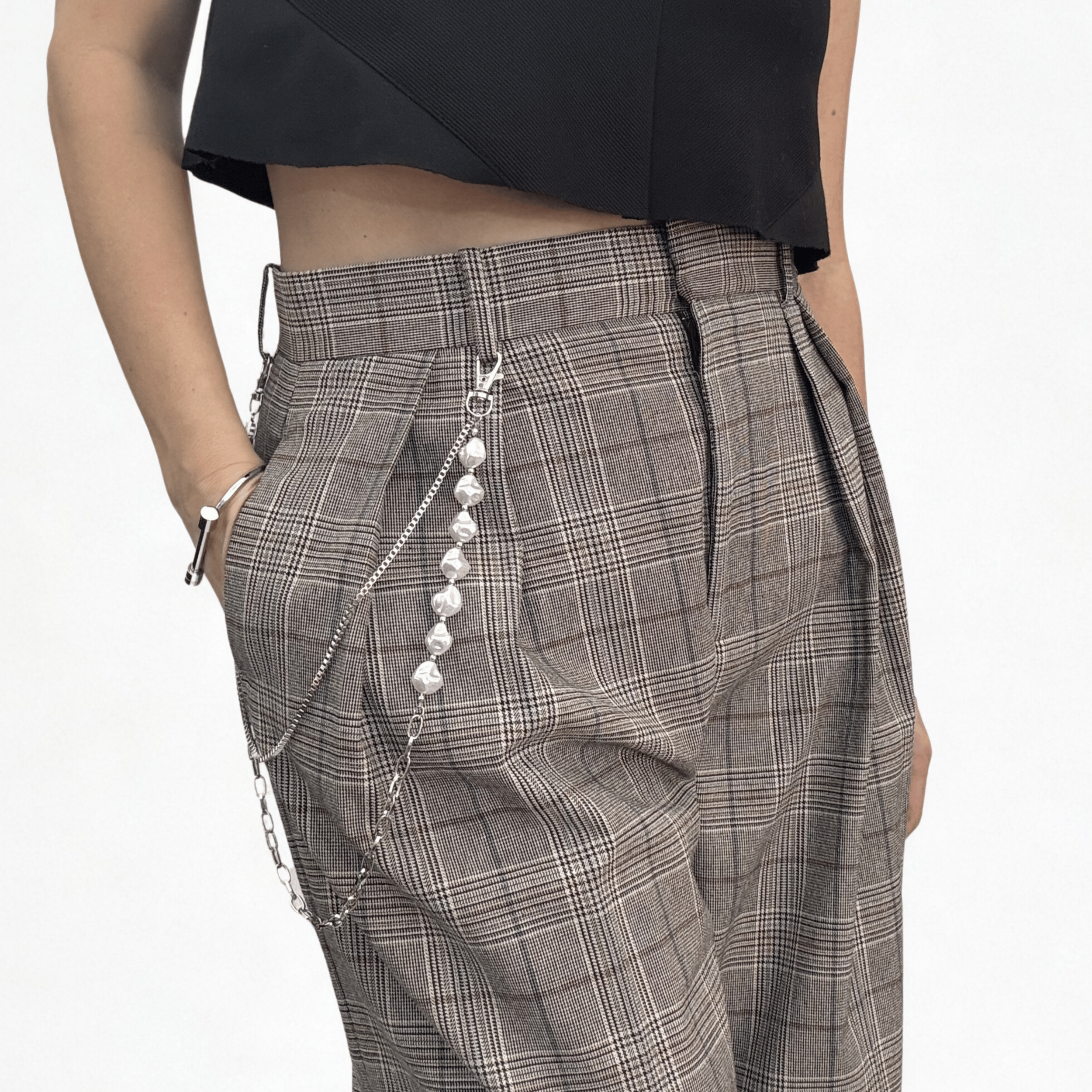 Trouser chain which consists of two layered chains: a substantial, classic curb link and a delicate faux pearl chain, styled on a pair of plaid wide leg trousers.