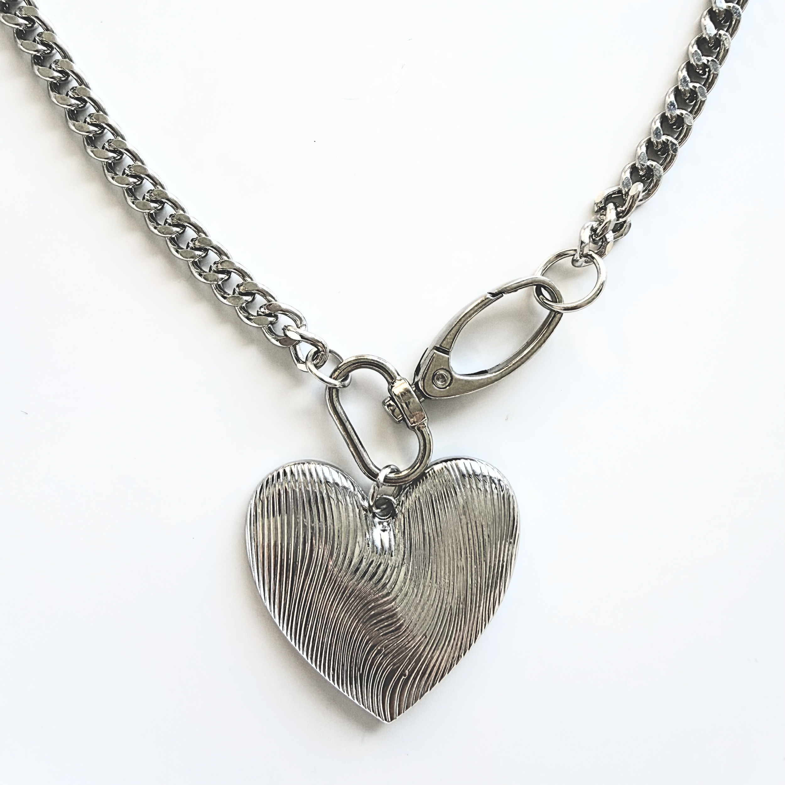 Close up of silver etched oversized heart pendant detailing the heavy duty clasp.
