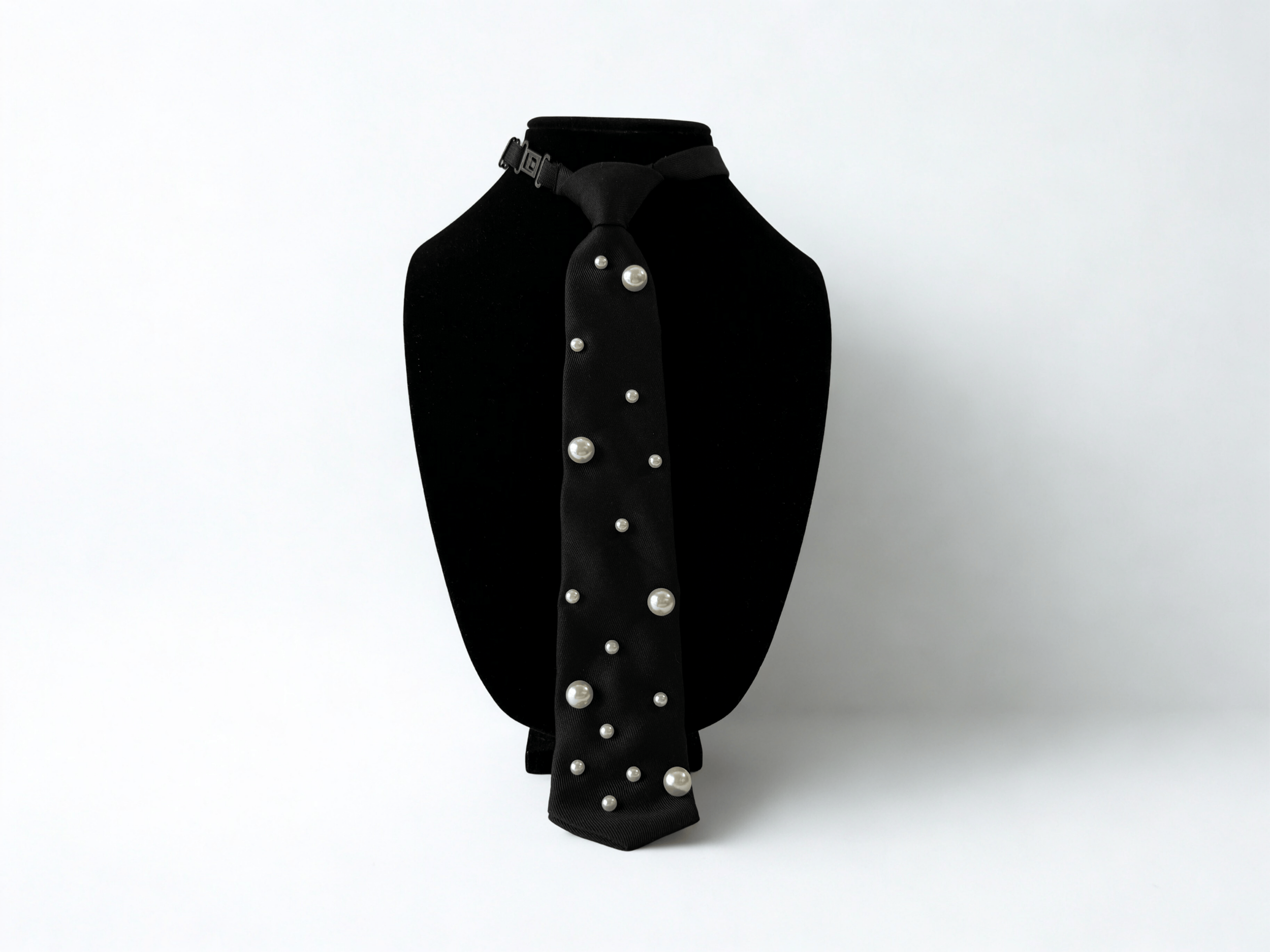 Close up of black tie with pearl detail and hidden adjustable necktie.