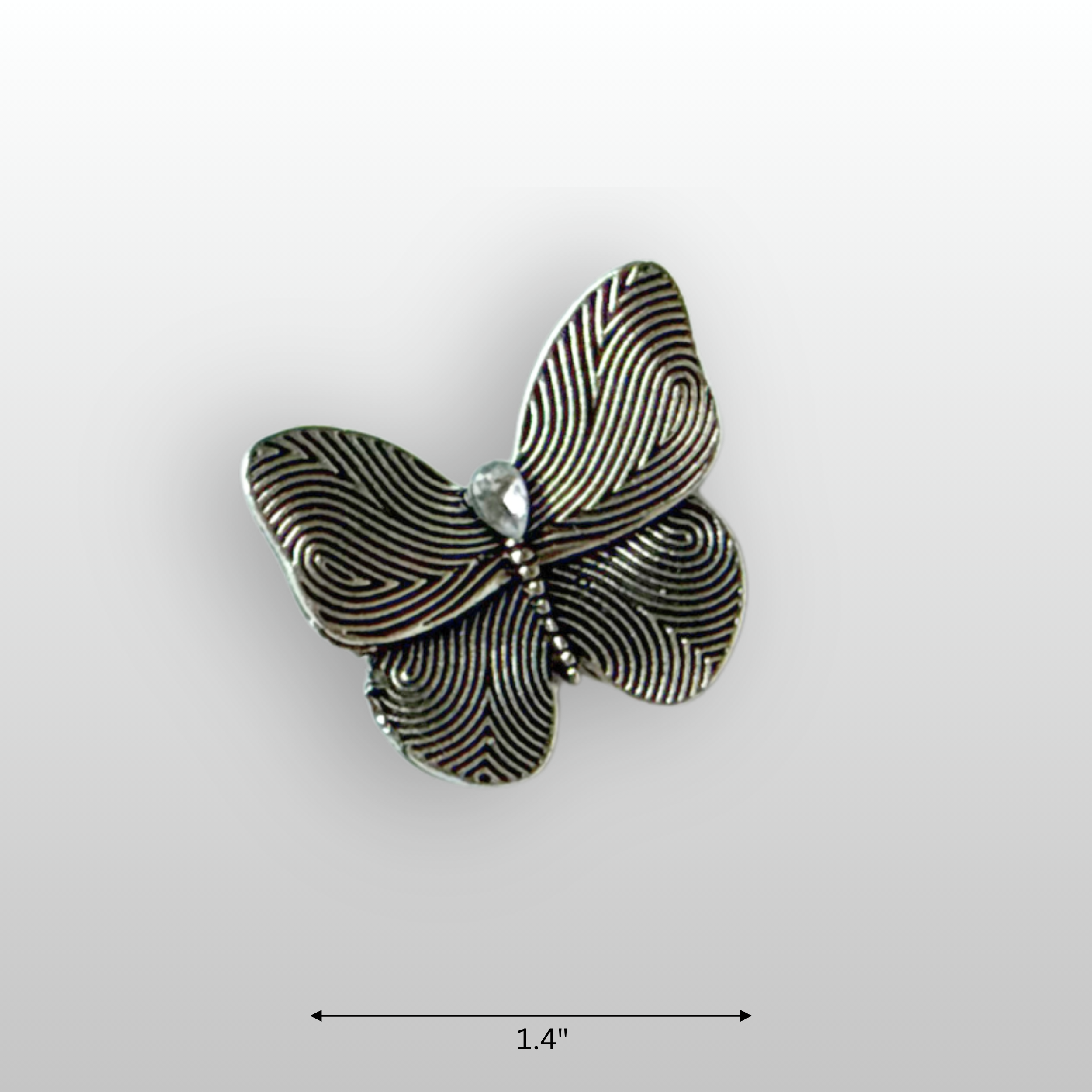Close up of small silver butterfly brooch, with a small teardrop glass crystal in the centre.