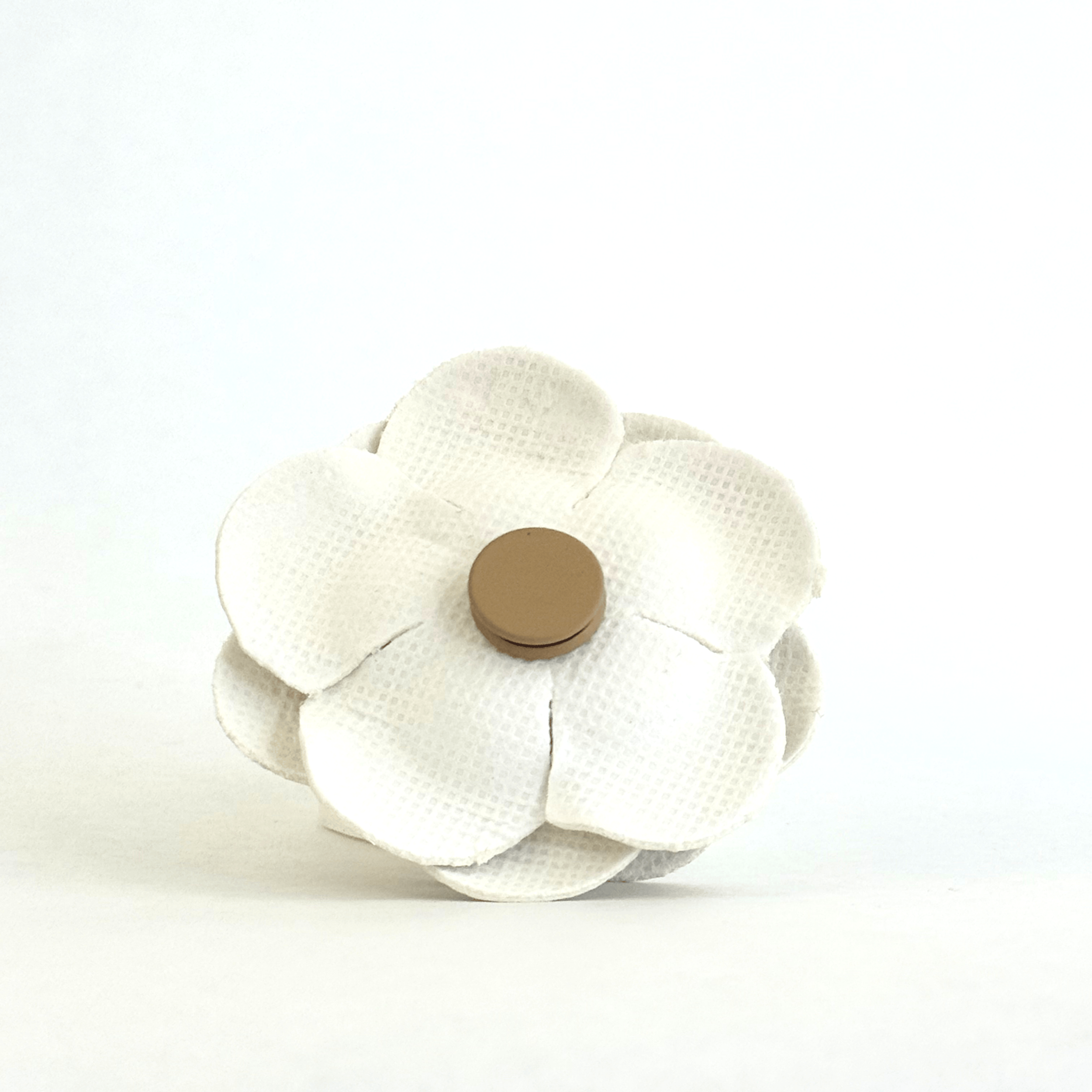 White faux leather rosette brooch showcasing magnetic closure on the back. .