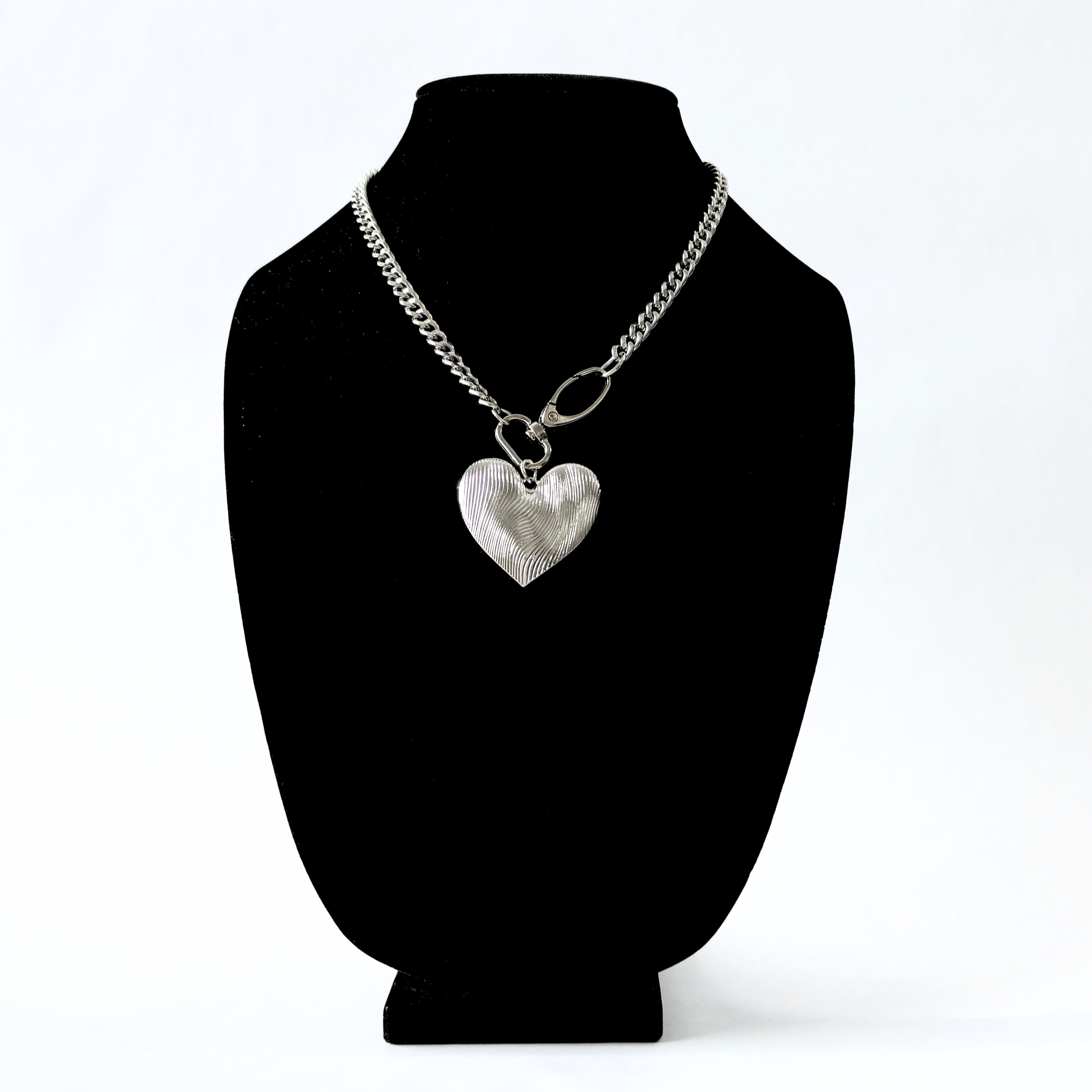 Close up of silver etched oversized heart pendant.