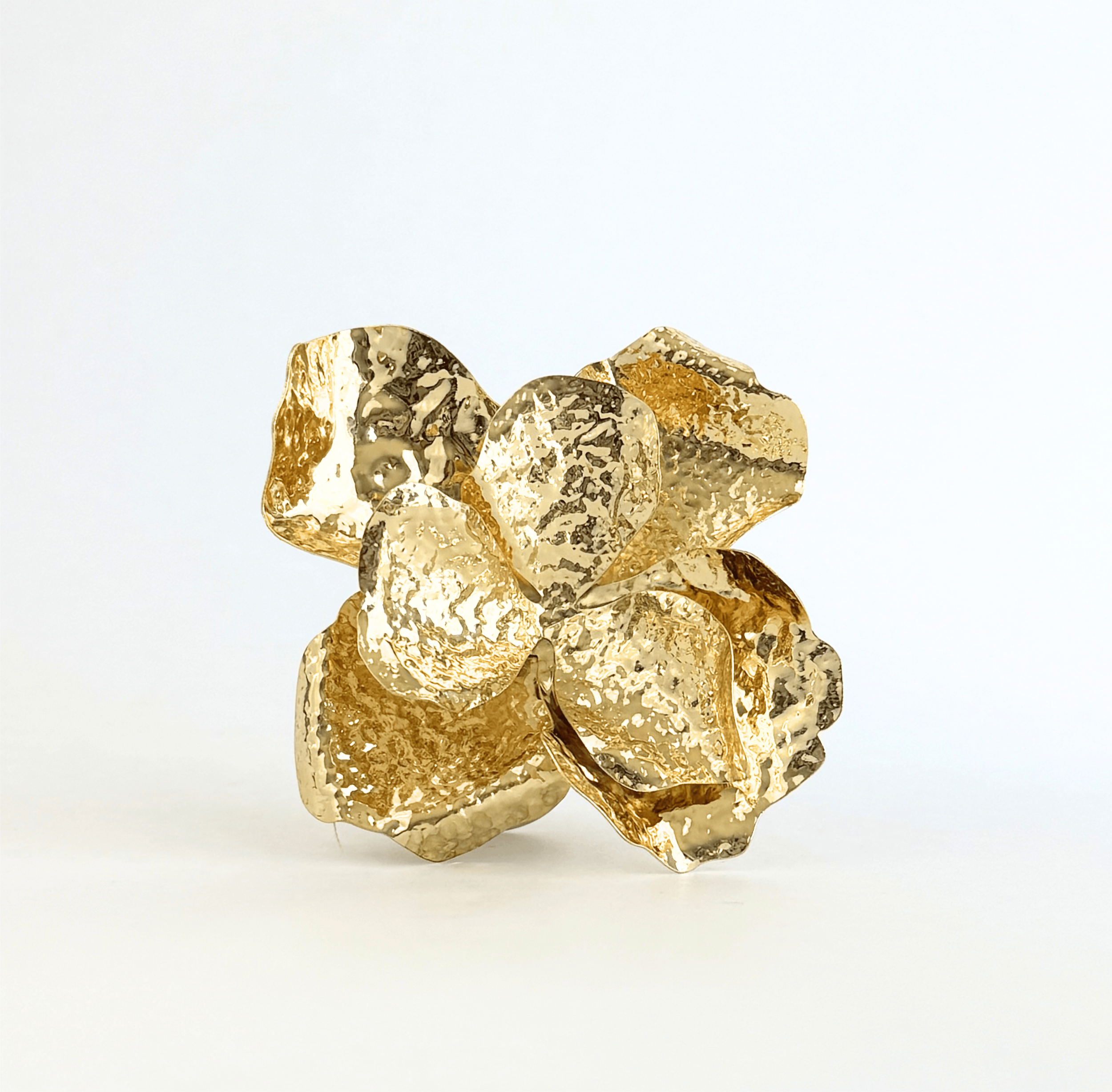 Close of of a 3D hammered golden floral brooch.