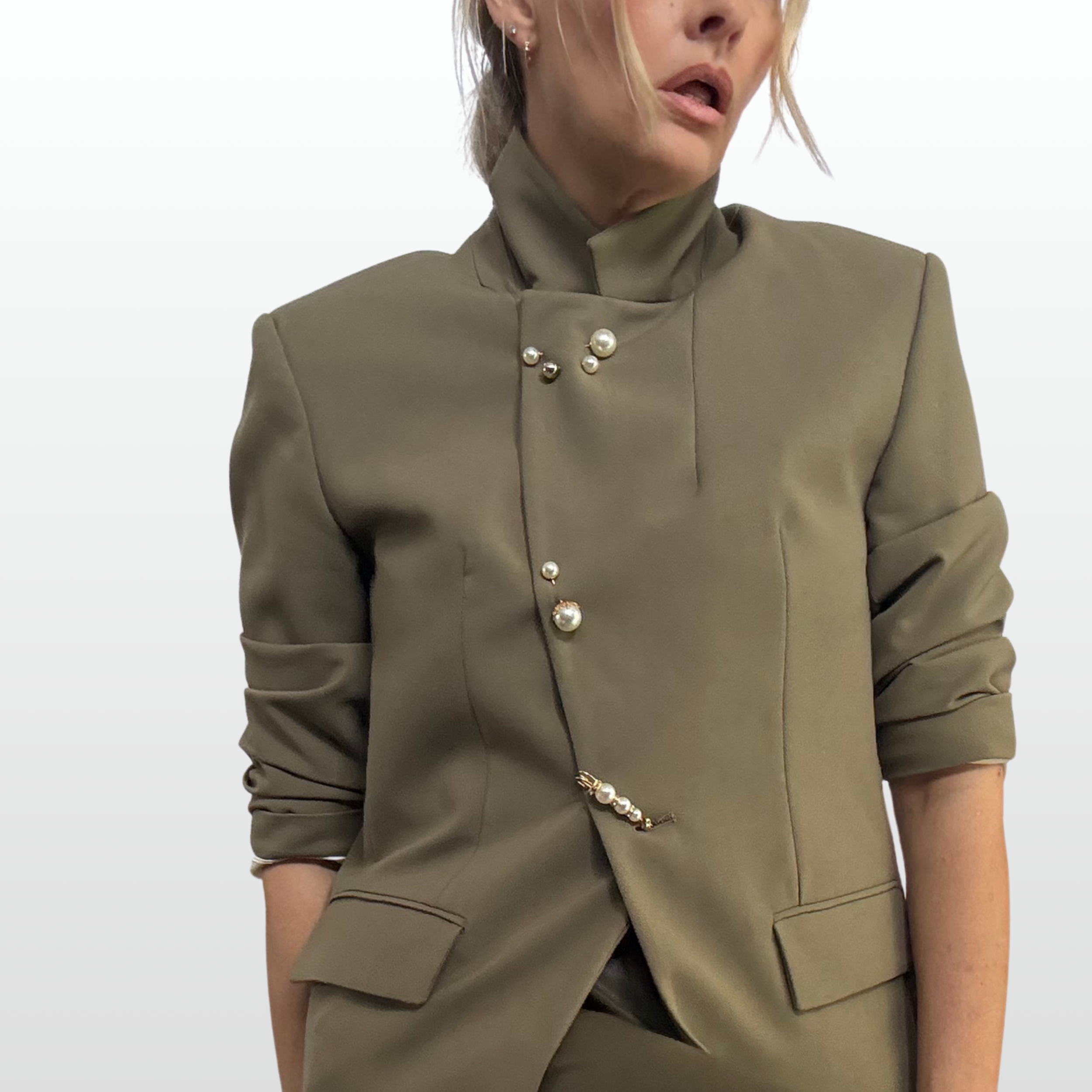 A set or pearl pin brooches down the front of a model's blazer.