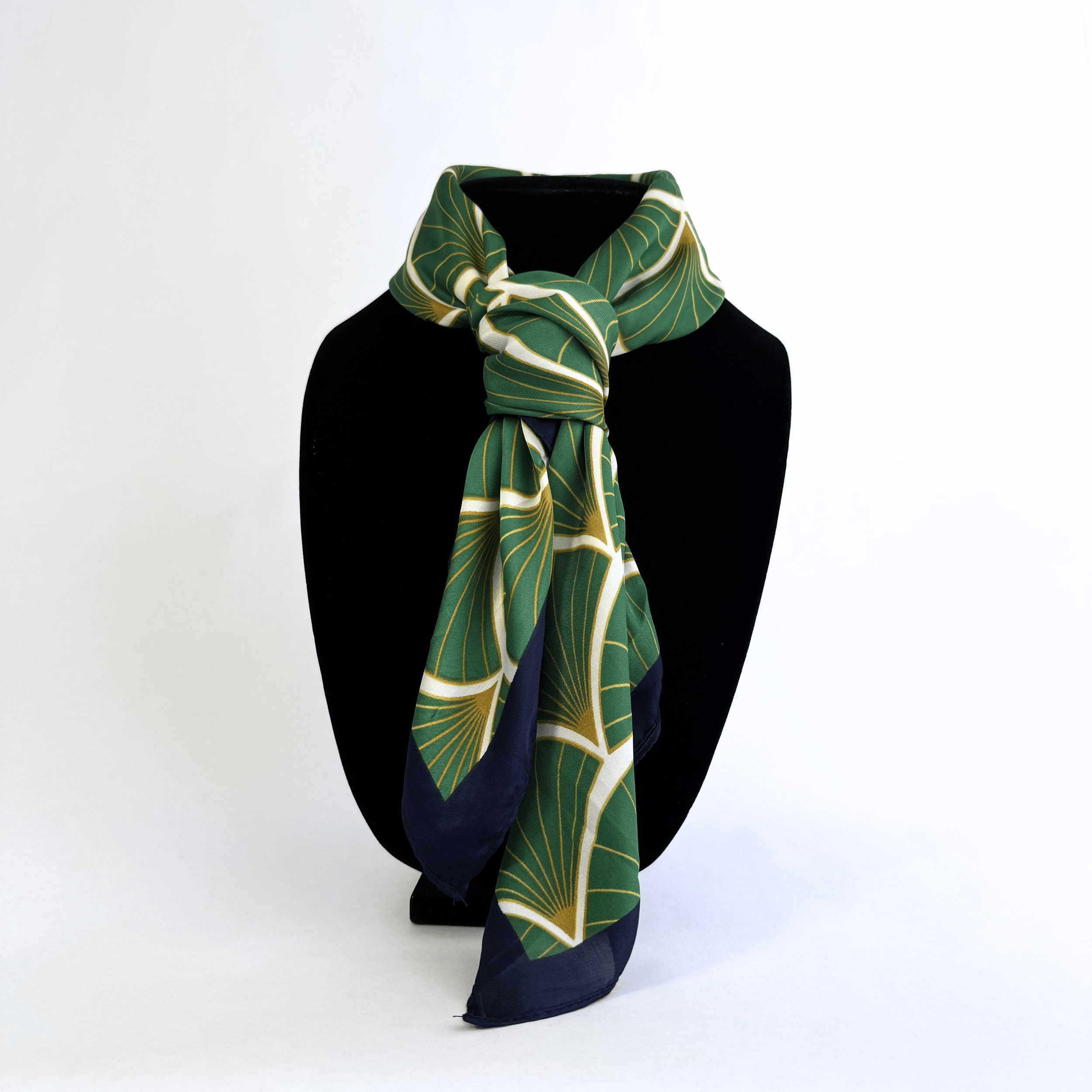 A rich, deep emerald green patterned square soft with yellow and white accents.  with a soft, matte lustre.