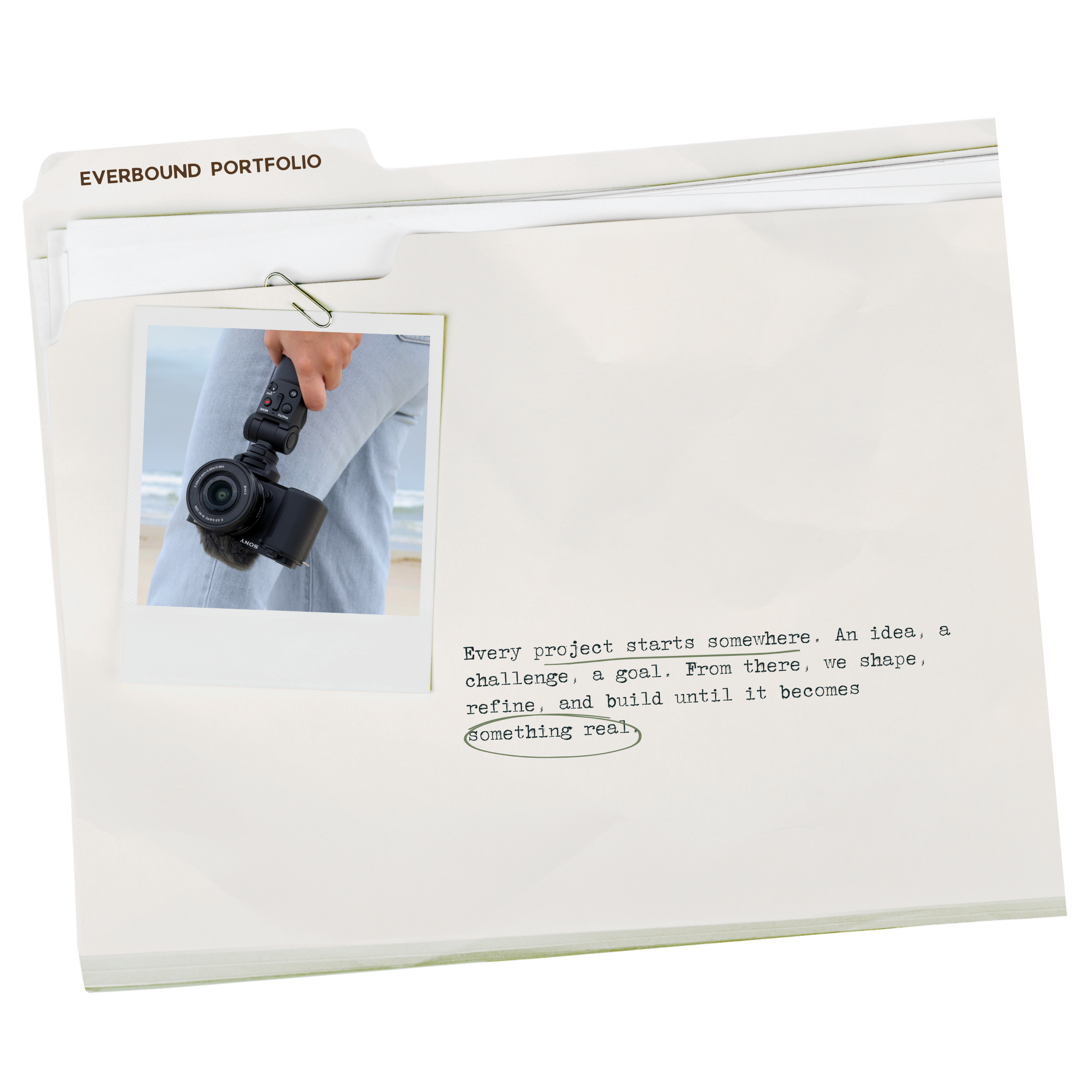 A white folder labeled "Everbound Portfolio" with a Polaroid-style photograph of a person holding a camera by a beach, accompanied by a page of typed text with some words underlined and circled.
