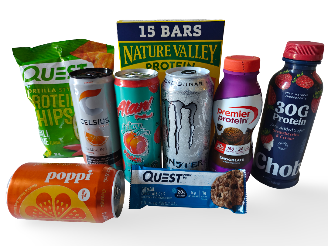 Assorted snacks and drinks including a bag of Quest tortilla chips, a box of Nature Valley protein bars, a can of Celsius sparkling orange drink, a can of Alani Juicy Peach beverage, a Thirst Monster energy drink, a Premier Protein chocolate shake, a bottle of strawberry and cream flavored protein, a Poppi orange soda, a Quest oatmeal chocolate chip protein bar, and a Chobani strawberry and cream yogurt drink.