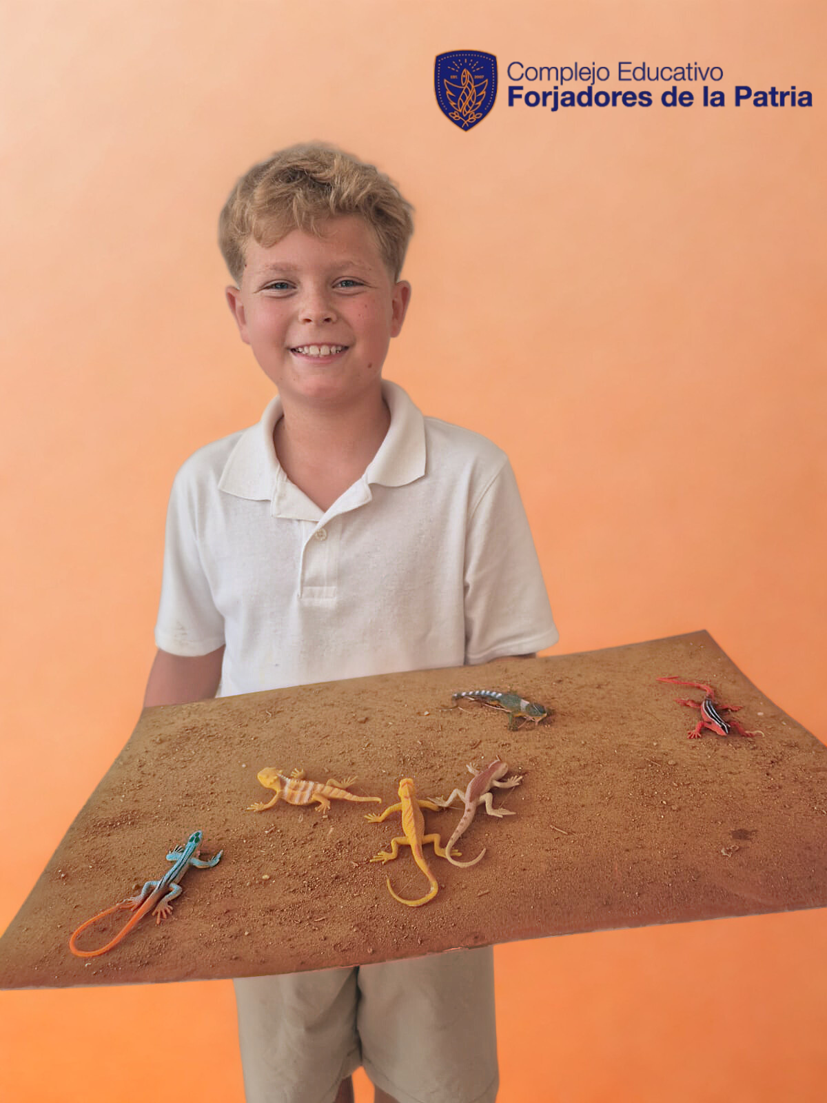 Un niño con camiseta blanca sostiene una mesa con varias figuras de lagartos en un fondo anaranjado. En la esquina superior derecha, el logotipo y texto que dice 'Complejo Educativo Forjadores de la Patria'.