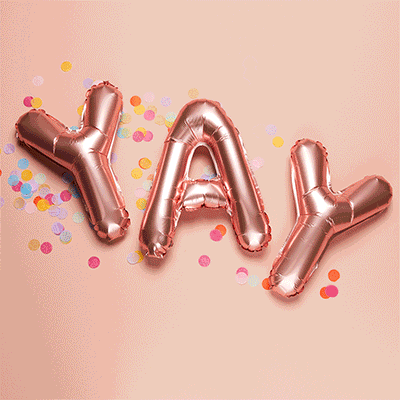A gif of a balloon sign that says YAY with confetti bring sprinkled on it