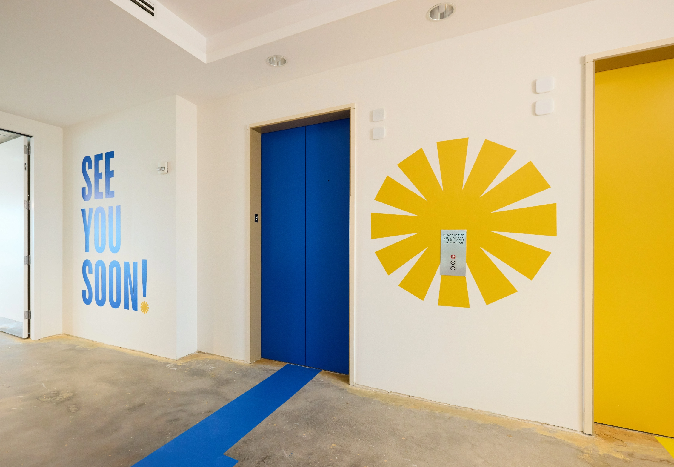 exit elevator bank with see you soon on the wall and floor graphics
