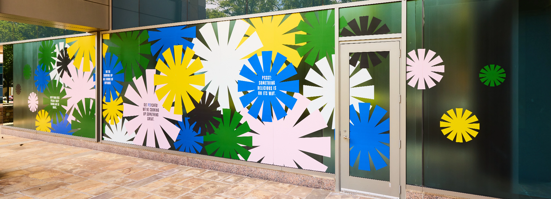 outdoor window graphics with colorful brand mark scattered around and brand messaging