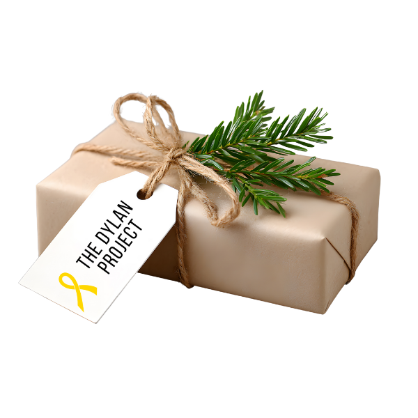 A beige gift box wrapped with twine string, topped with a sprig of pine and a white gift tag that reads "The Dylan Project" with a yellow awareness ribbon.